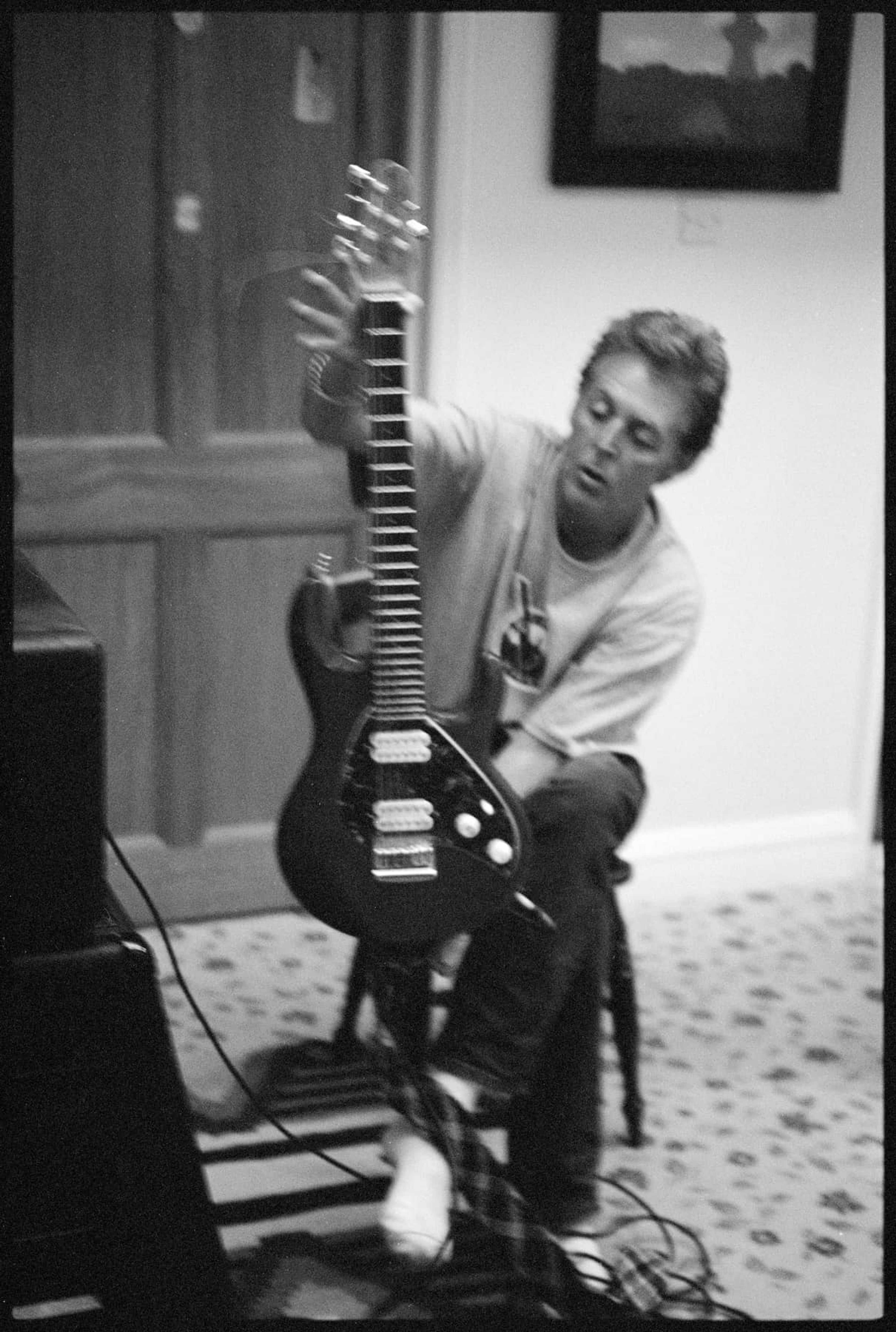 Photo of Paul playing guitar in 1996. This photo became a polaroid transfer which became the cover for 'Flaming Pie'