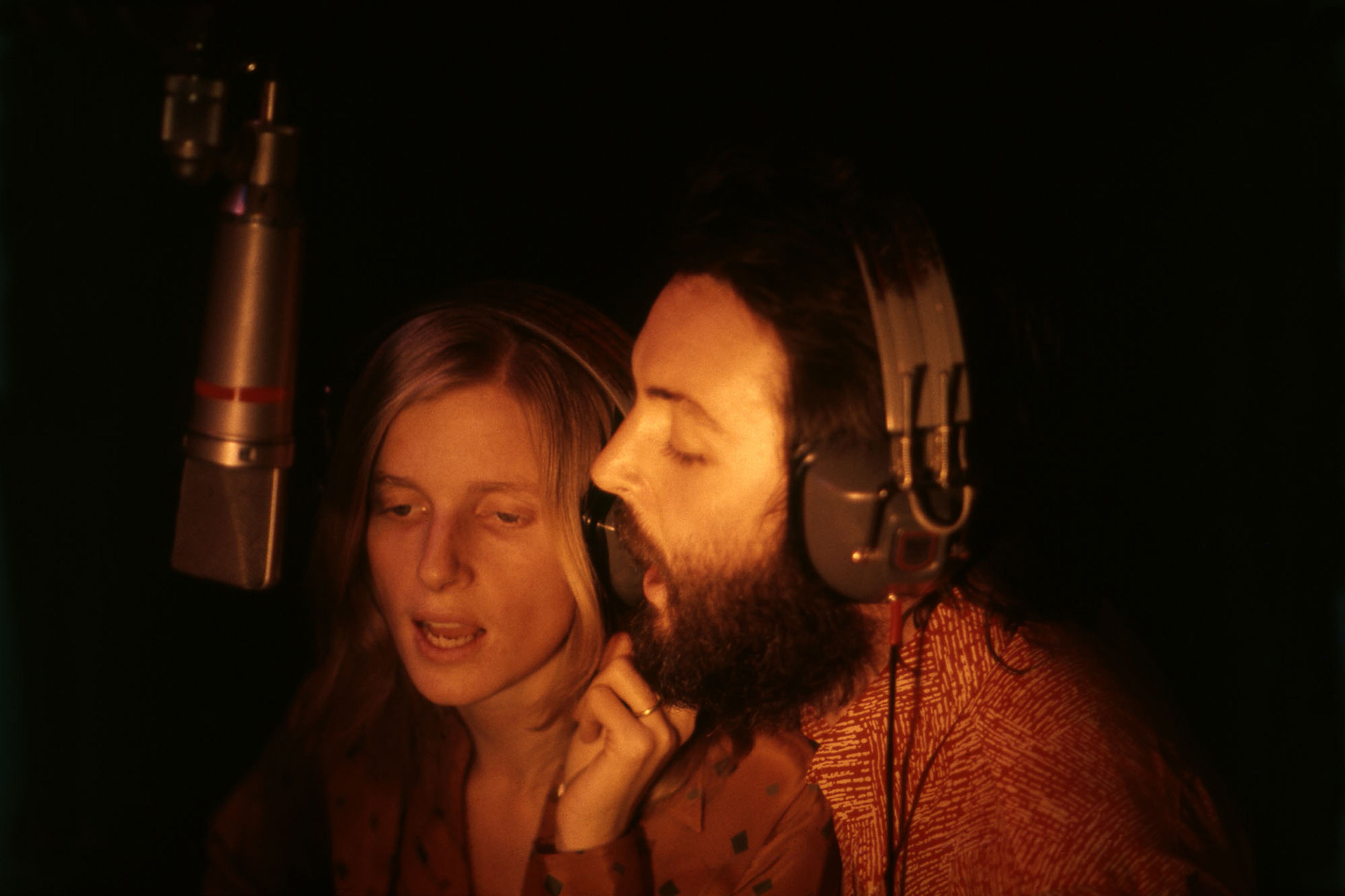 Paul and Linda McCartney singing into a studio microphone