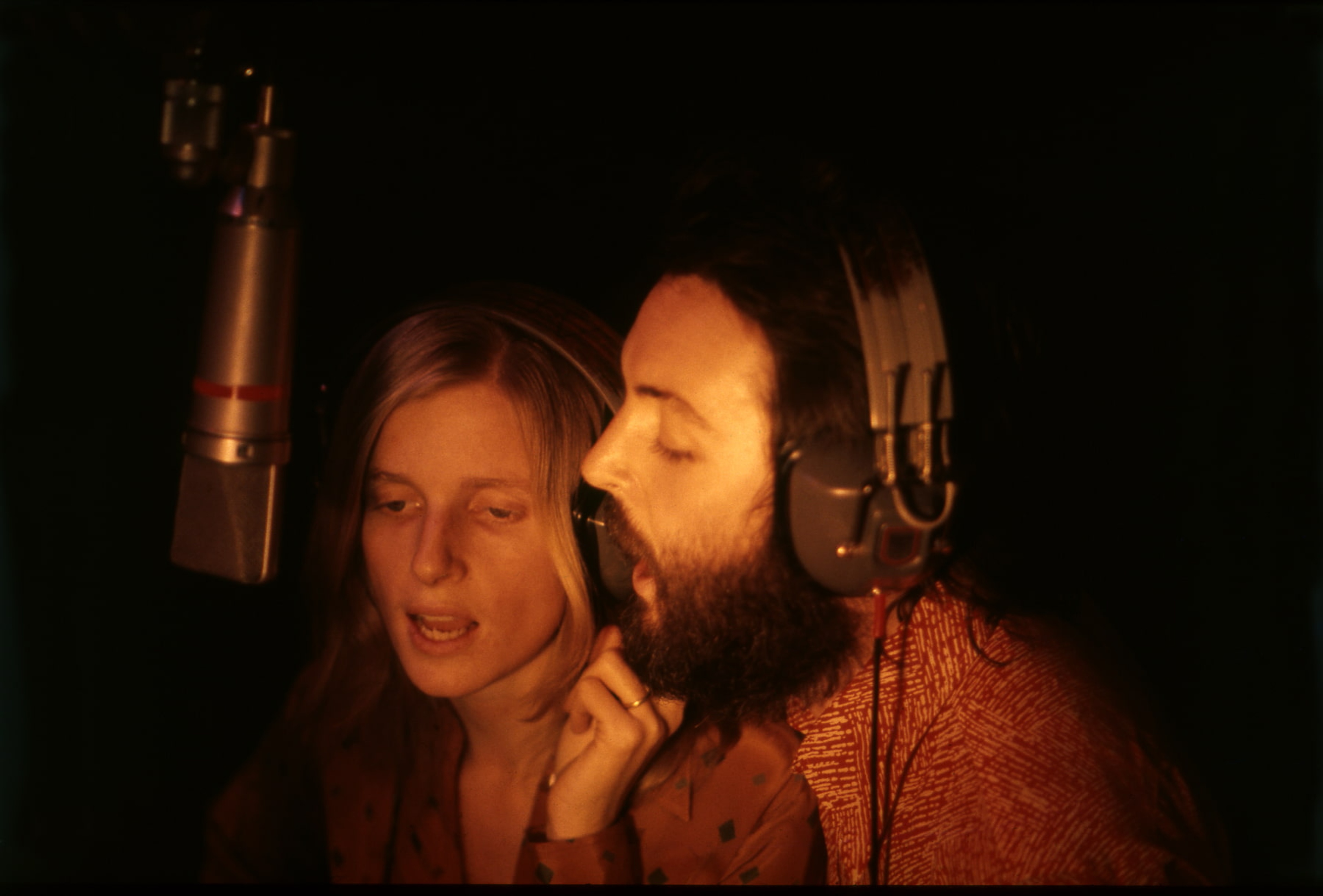 Paul and Linda McCartney singing into a studio microphone