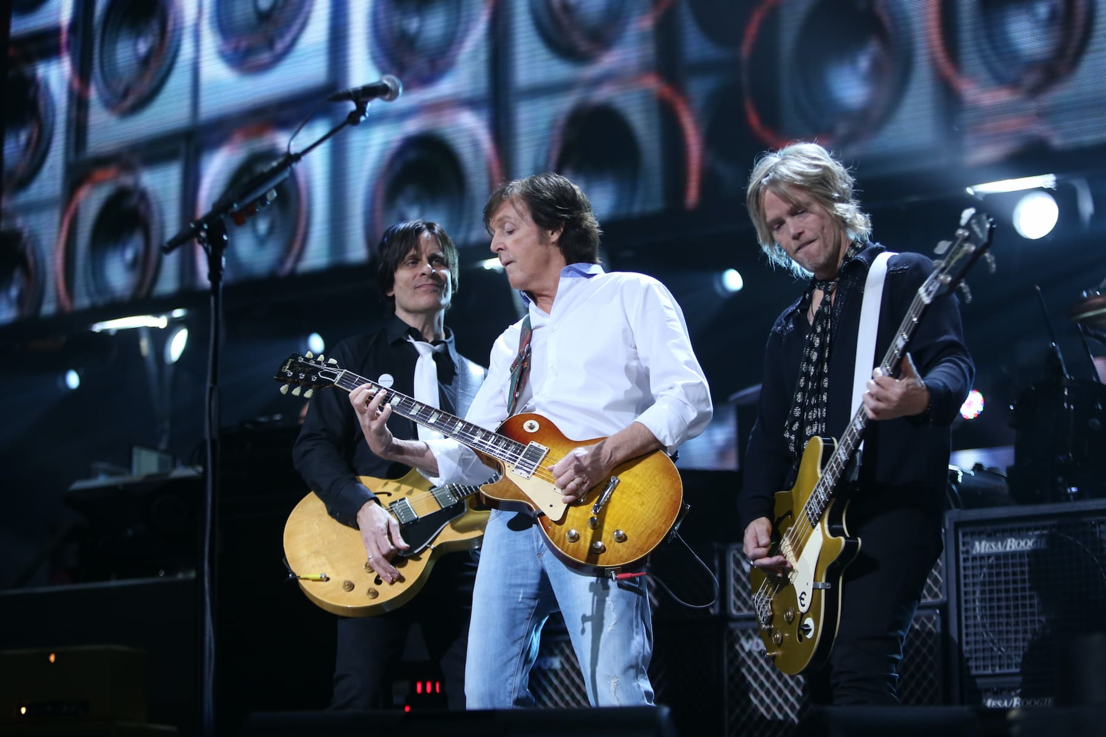 Photo of Paul playing bass on stage with Rusty Anderson and Brain Ray during the 12-12-12 benefit concert.