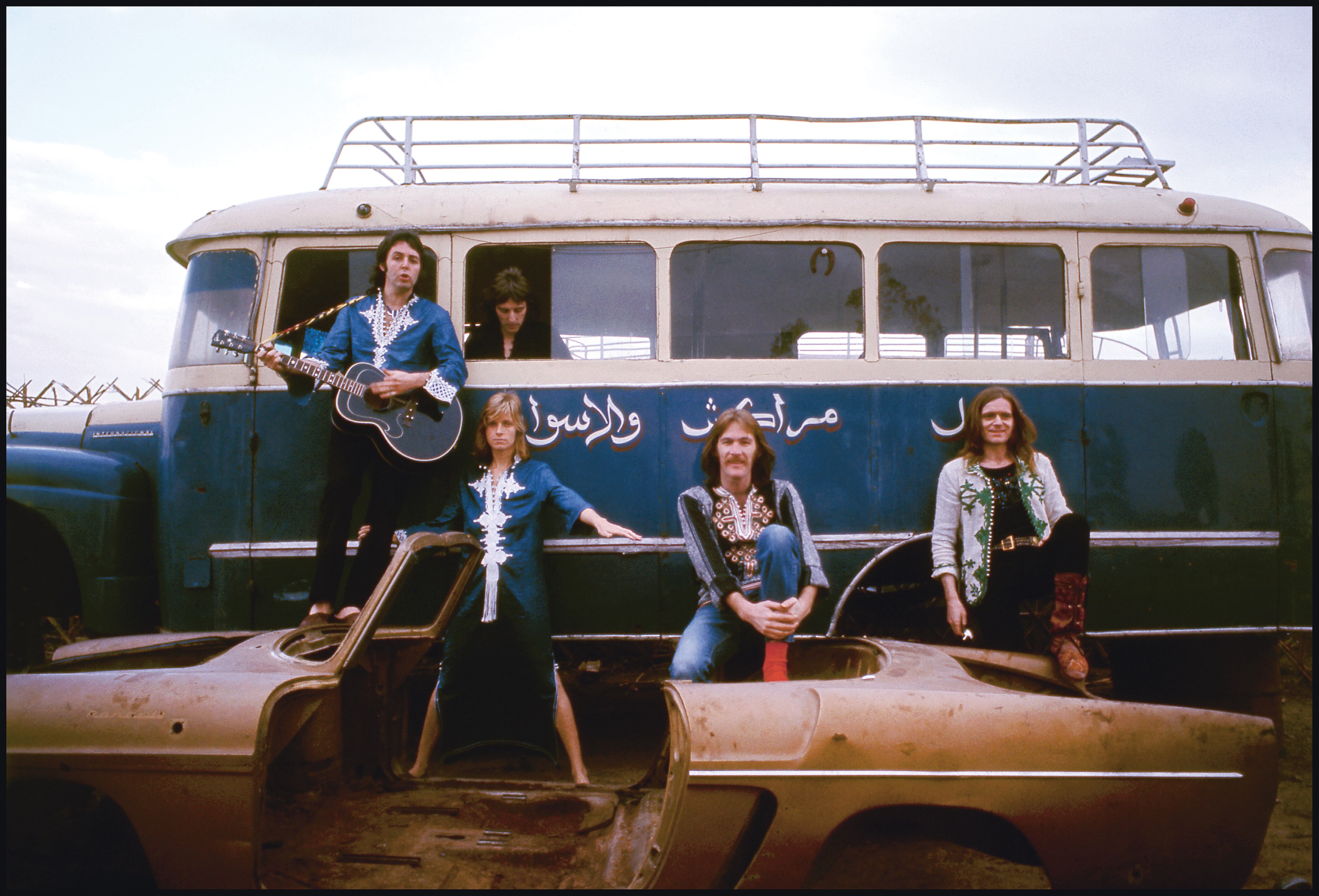 Wings stand in front of a blue camper van