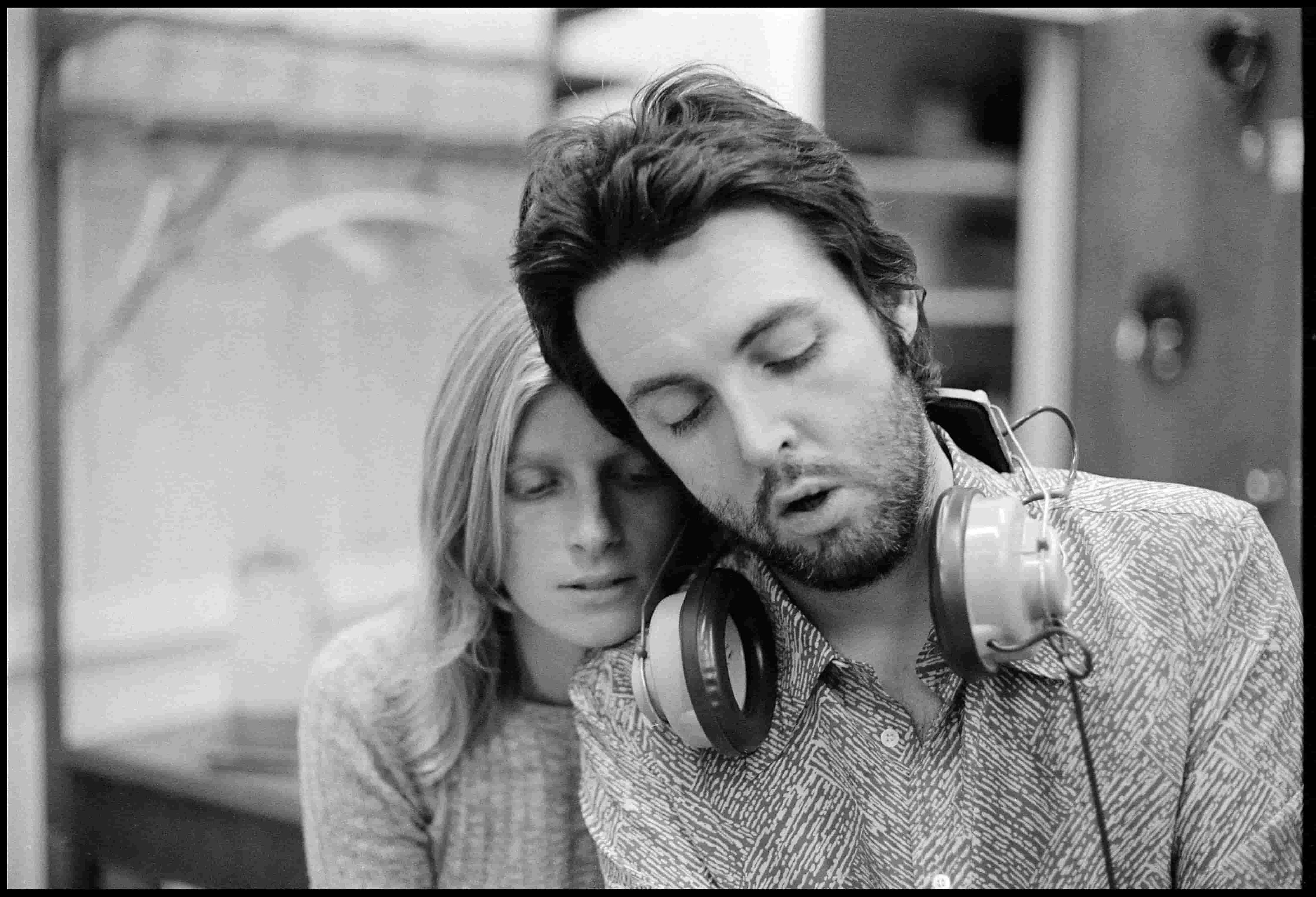 Linda and Paul McCartney leaning on each other and recording music