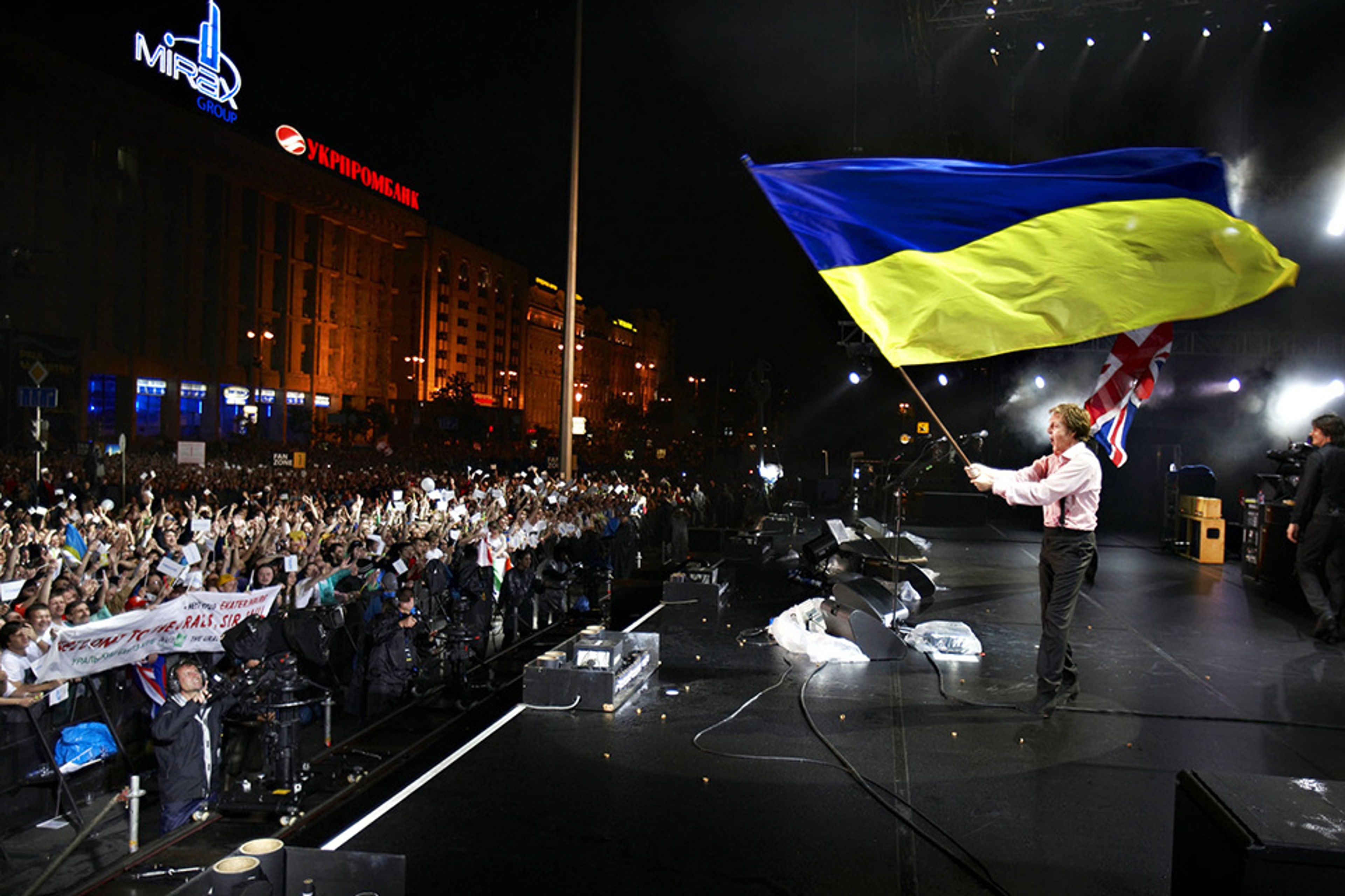 Photo of Paul waving Ukraine flag at a free concert in Independence Square in Kyiv.