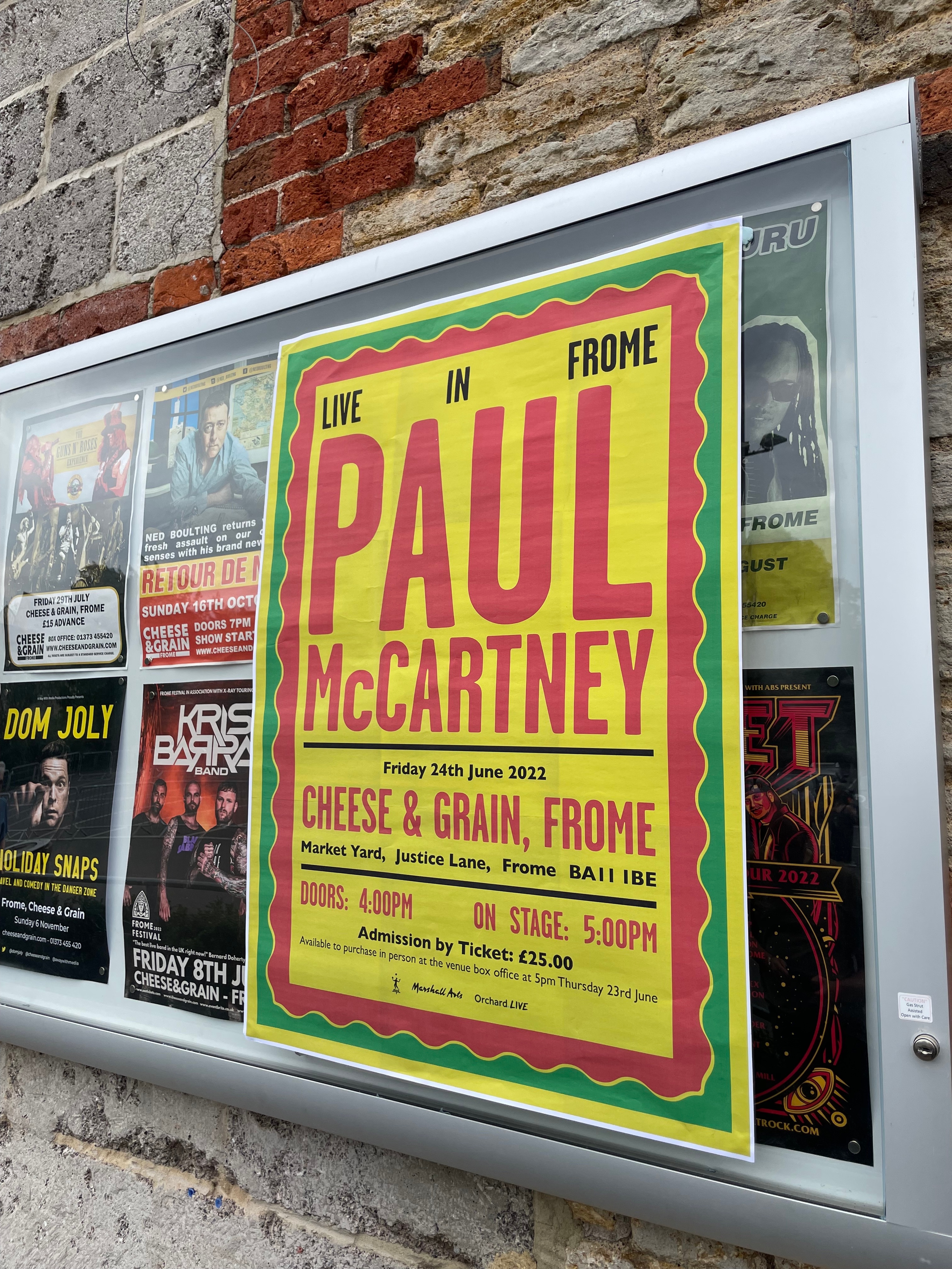 Yellow poster with red writing advertising Paul's secret show at Cheese & Grain
