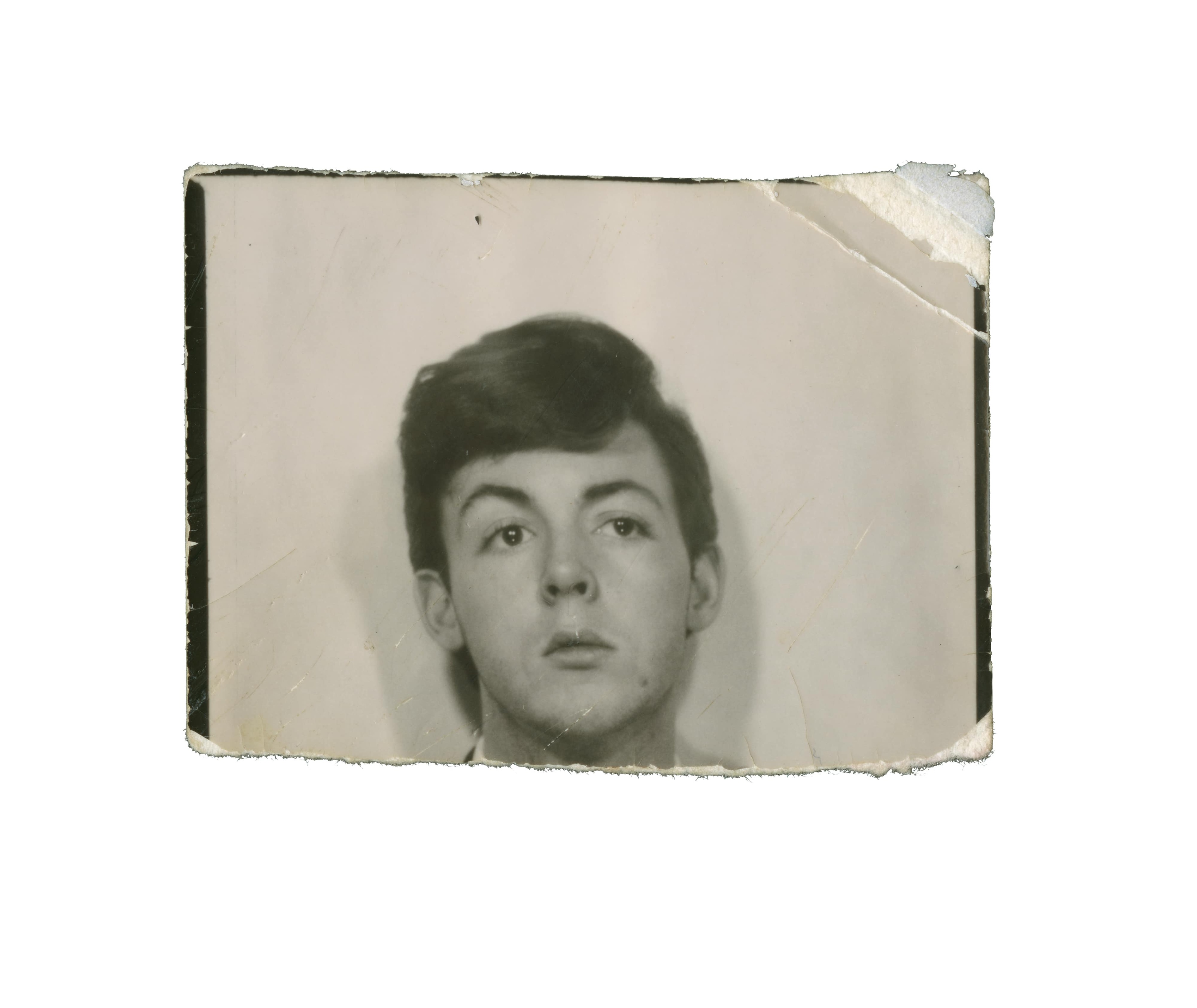 Photo of a young Paul McCartney on torn passport style paper
