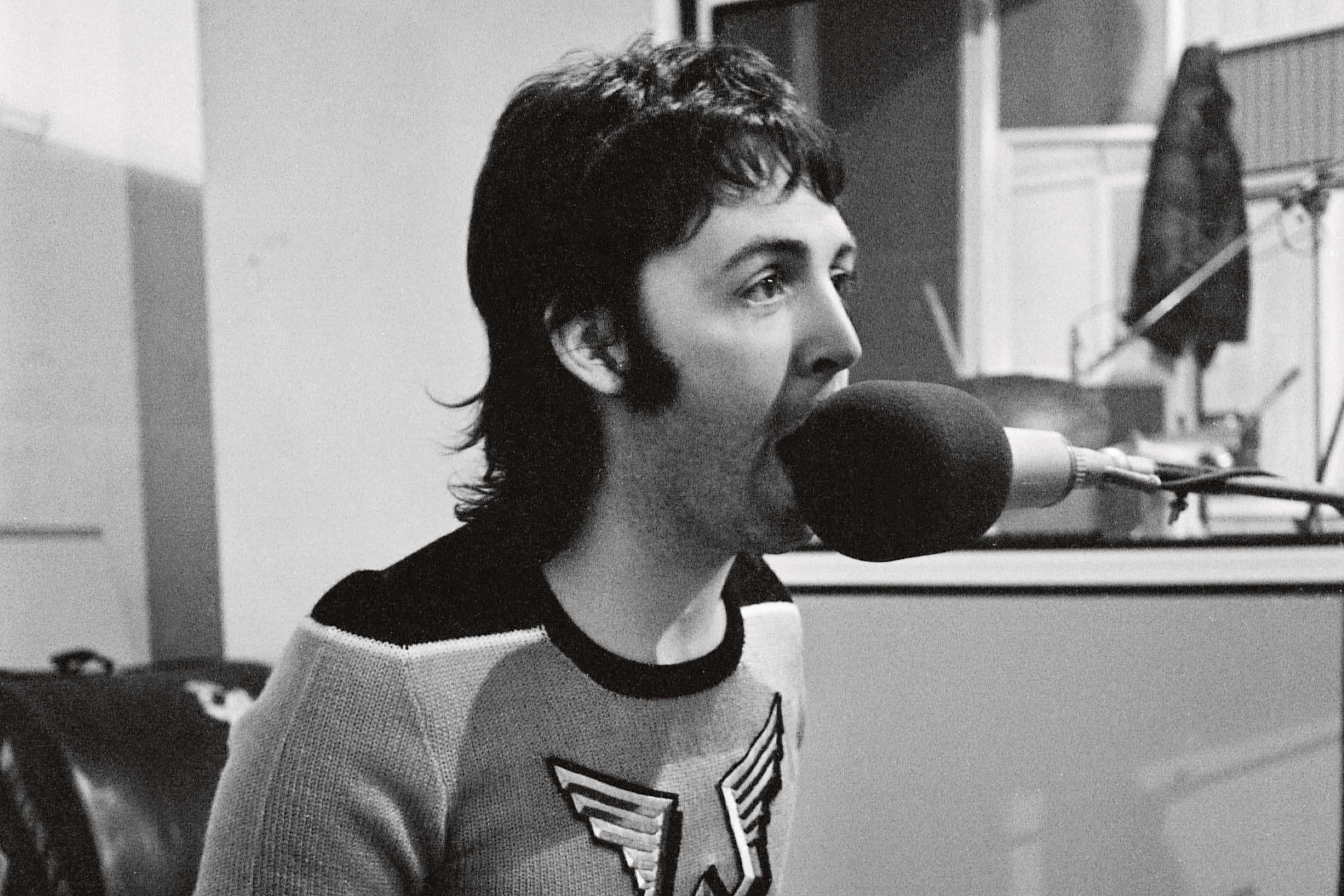 Black and white photo of Paul singing into a microphone