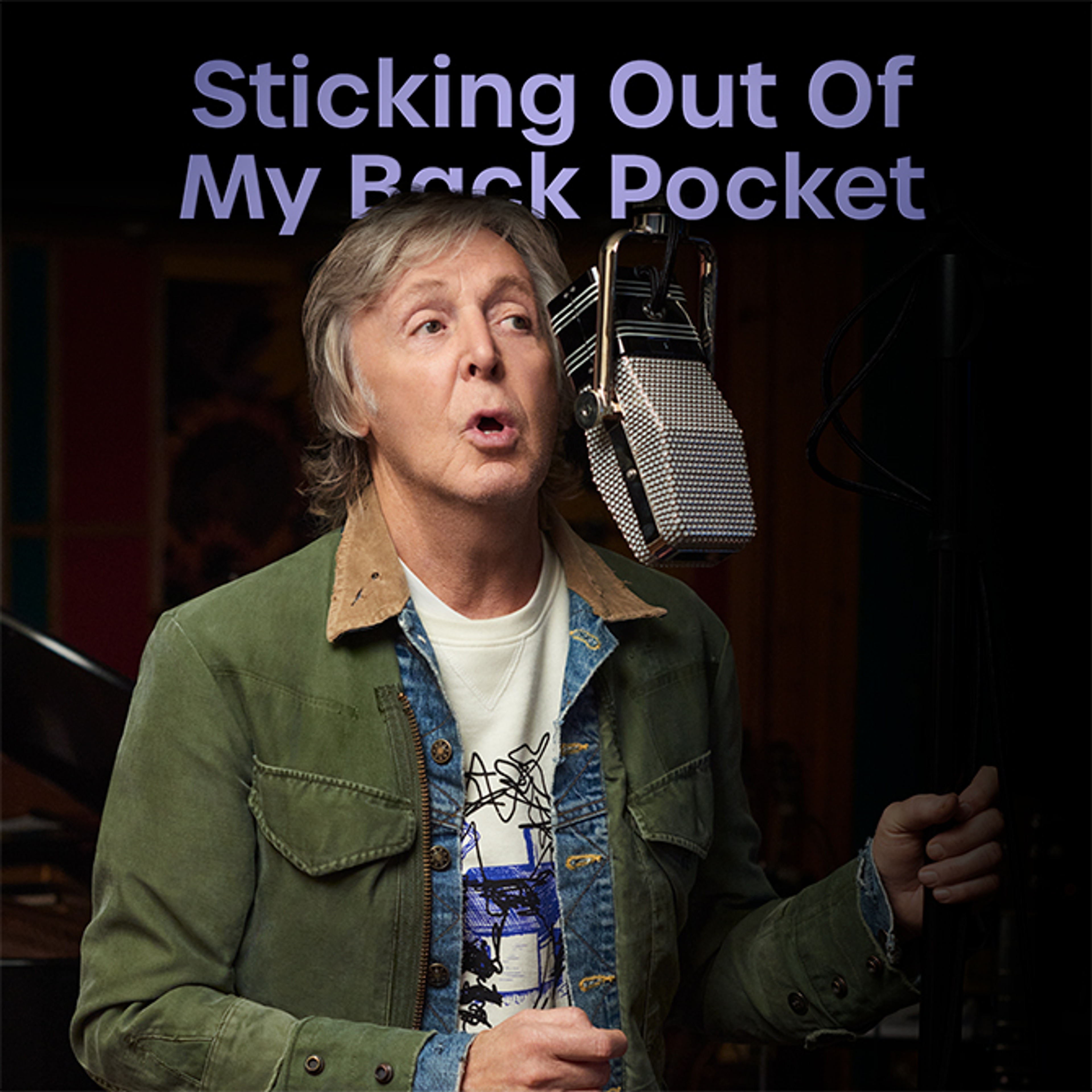Photo of Paul in the studio recording McCartney III with graphic text added on top with 'Sticking Out Of My Back Pocket' written on it in purple writing for November 2023's playlist.