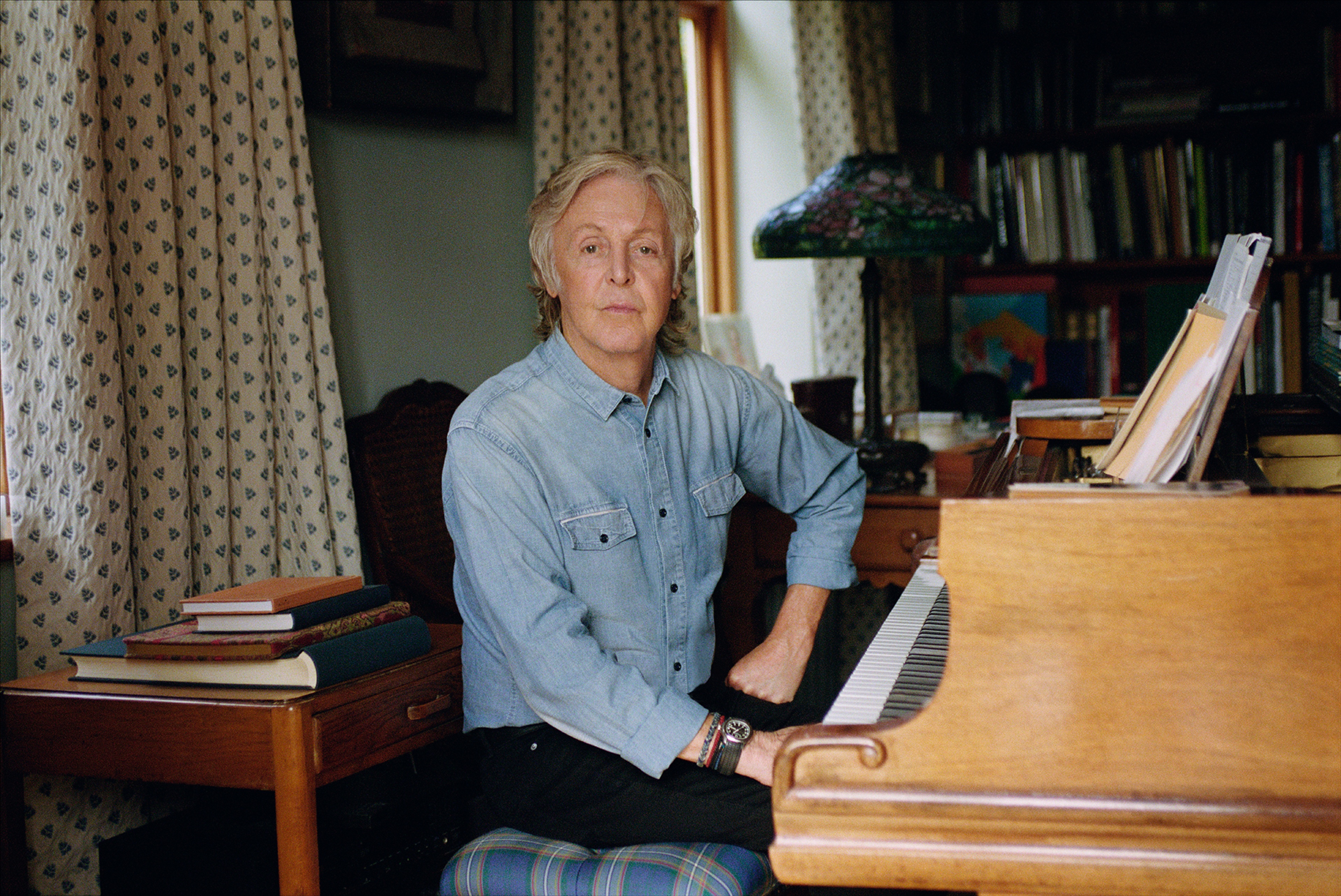 colour photo of Paul McCartney at home at a piano