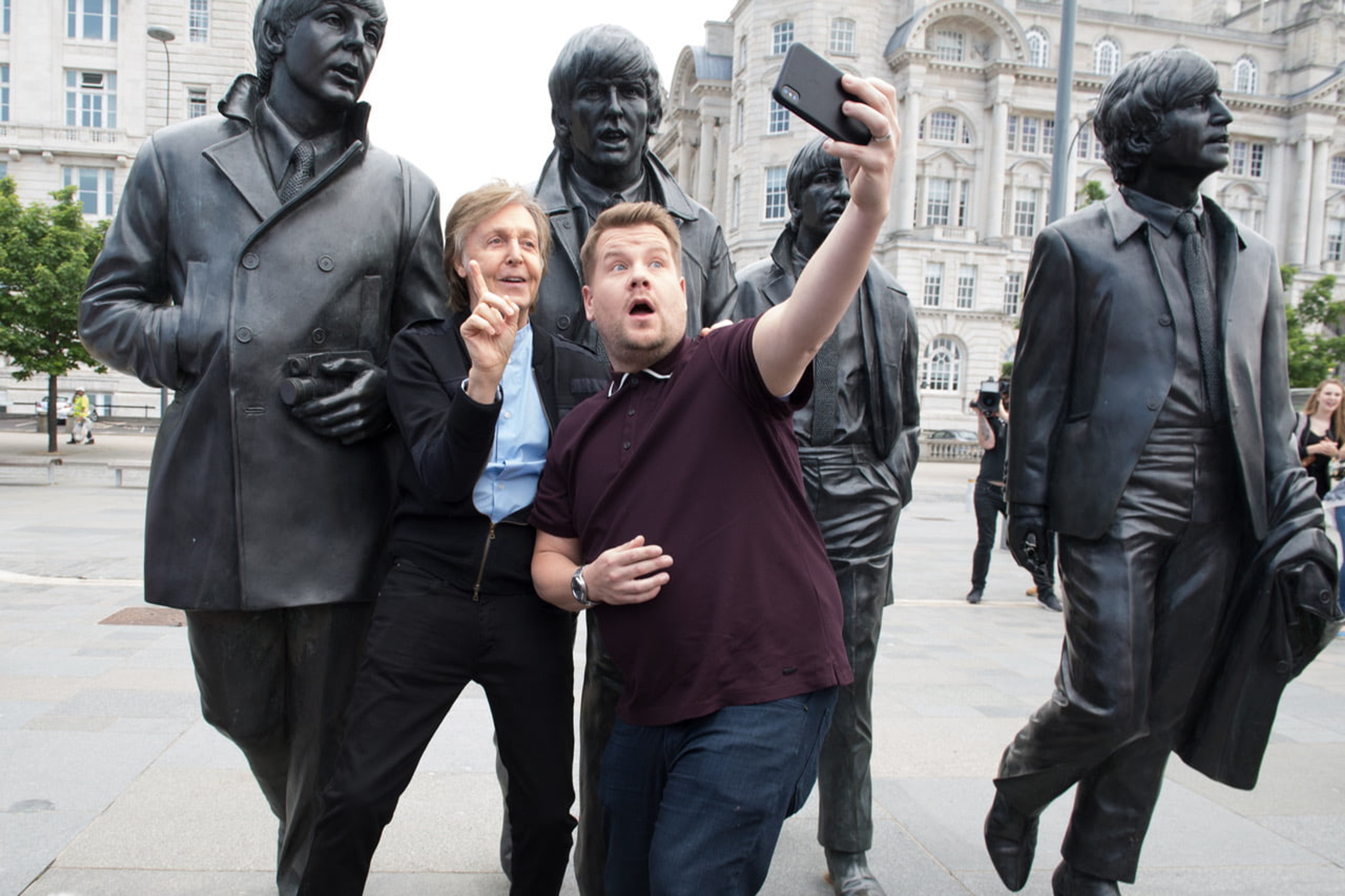 Photo of Paul and James Corden filming Carpool Karaoke in Liverpool next to The Beatles statues