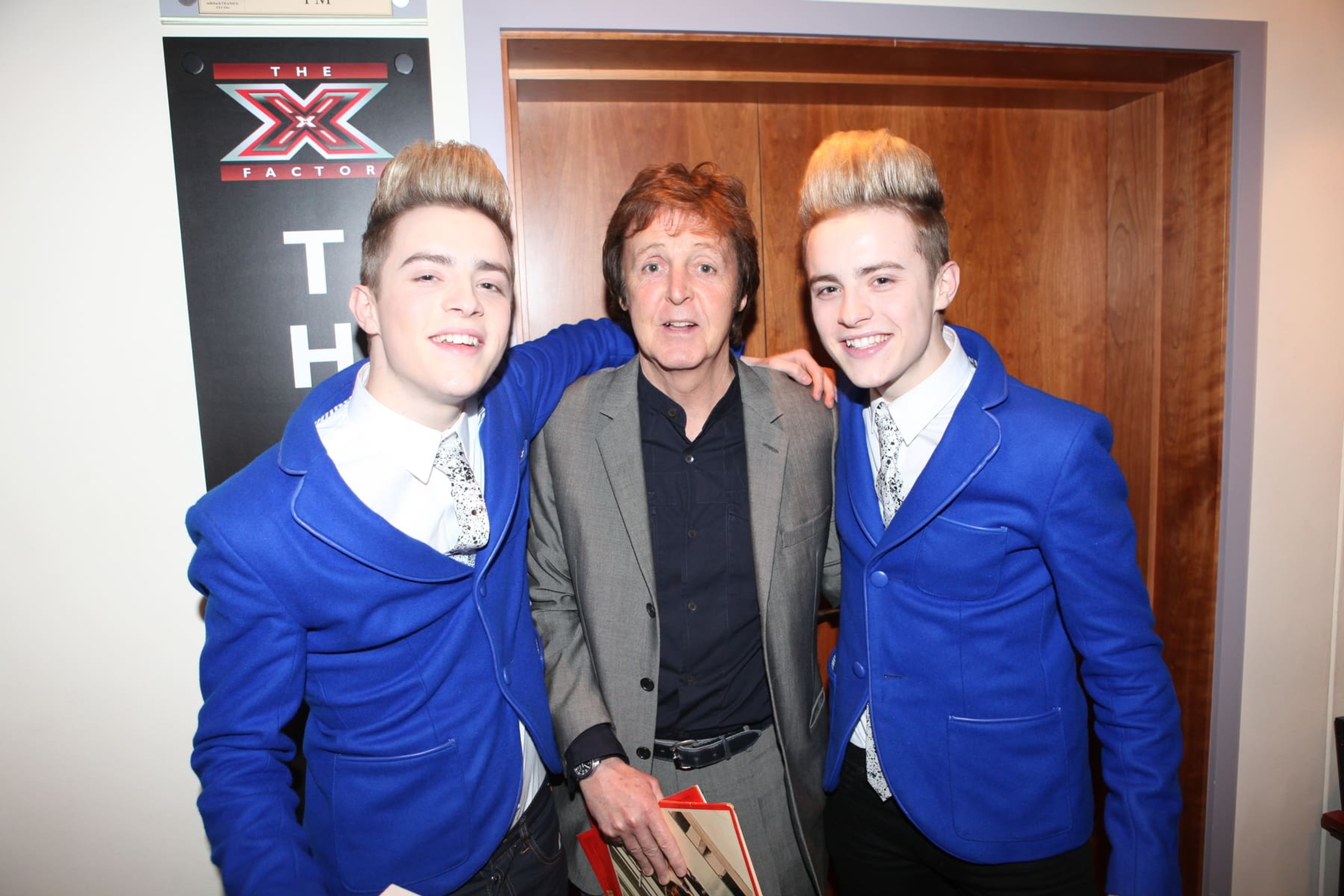 Paul standing in between twin X Factor contestants Jedward