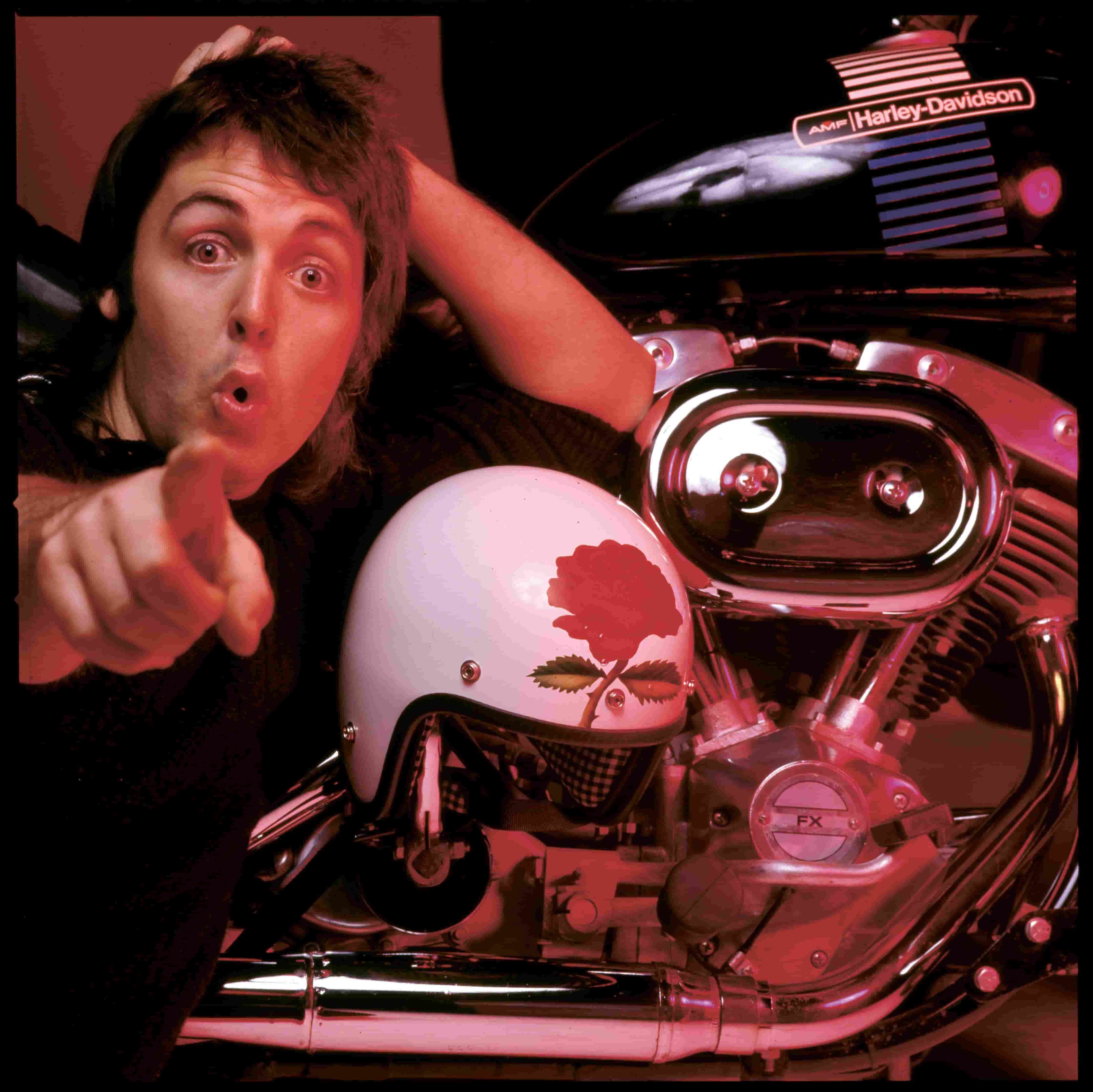Paul posing with a motorbike helmet and pointing at the camera