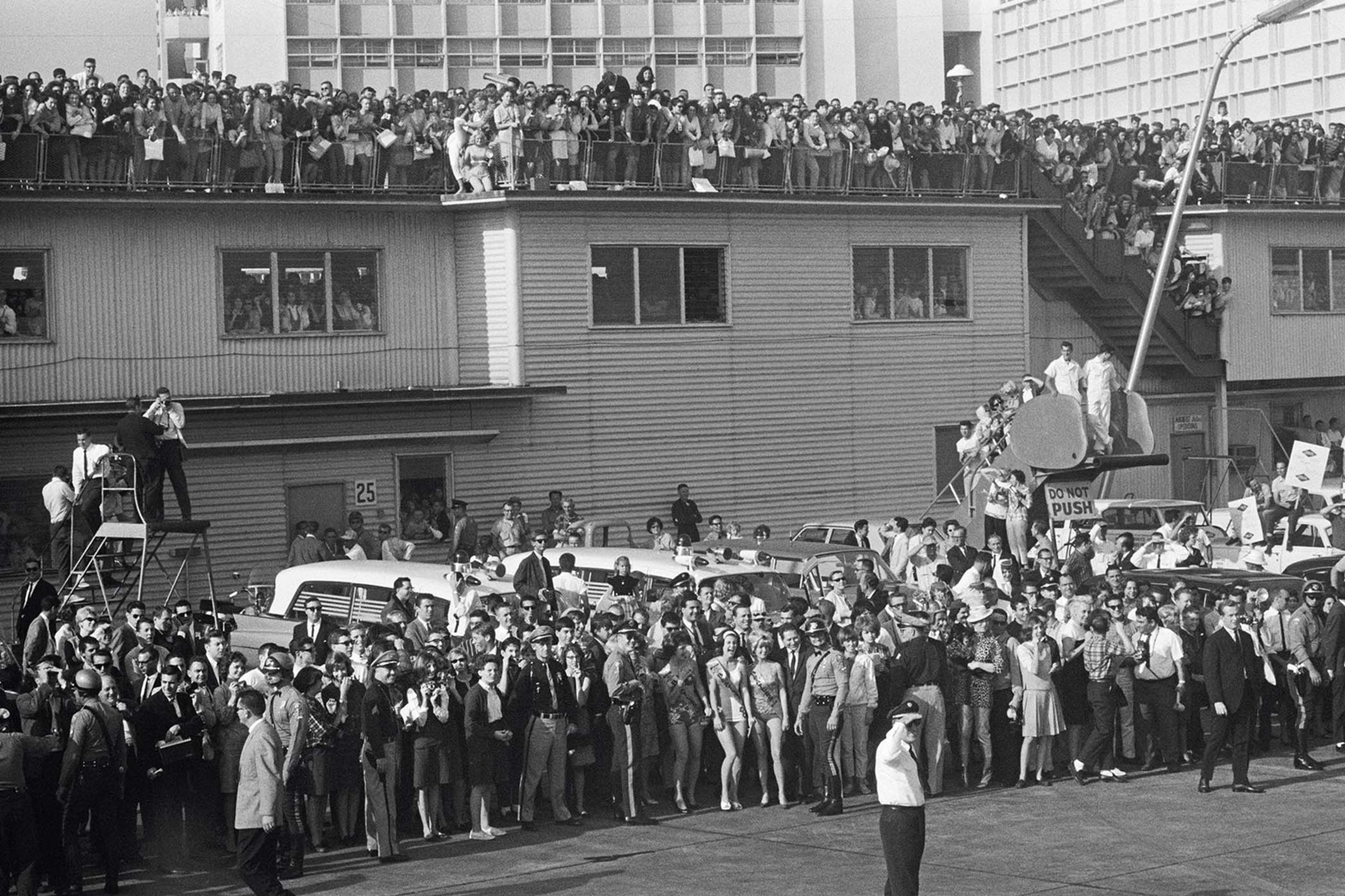 Black and white photograph taken by Paul McCartney showing a large crowd of people awaiting the arrival of The Beatles at Miami in 1964