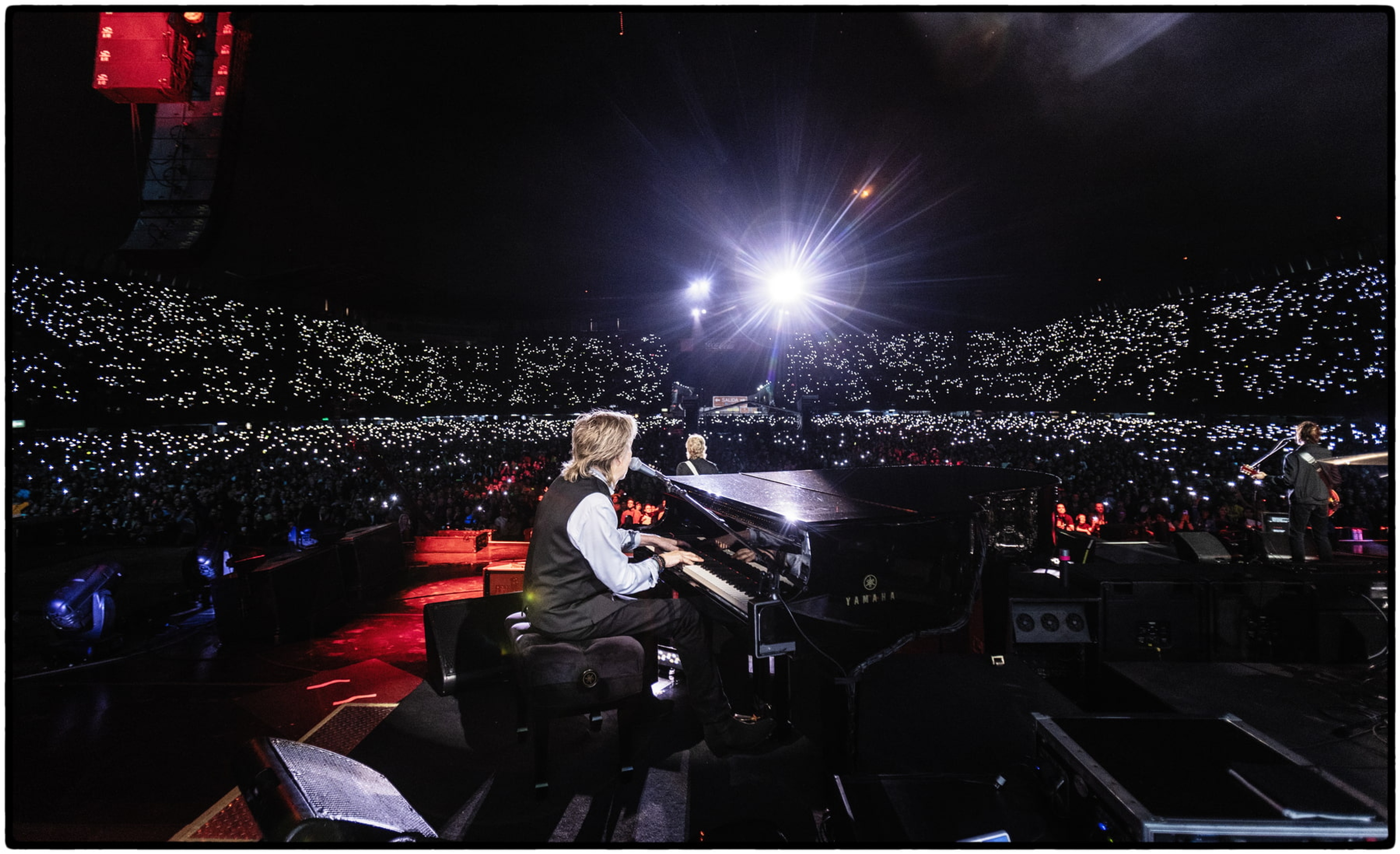 Photograph of Paul at the piano with he crowd behind him whilst he performs at Foro Sol in Mexico city.