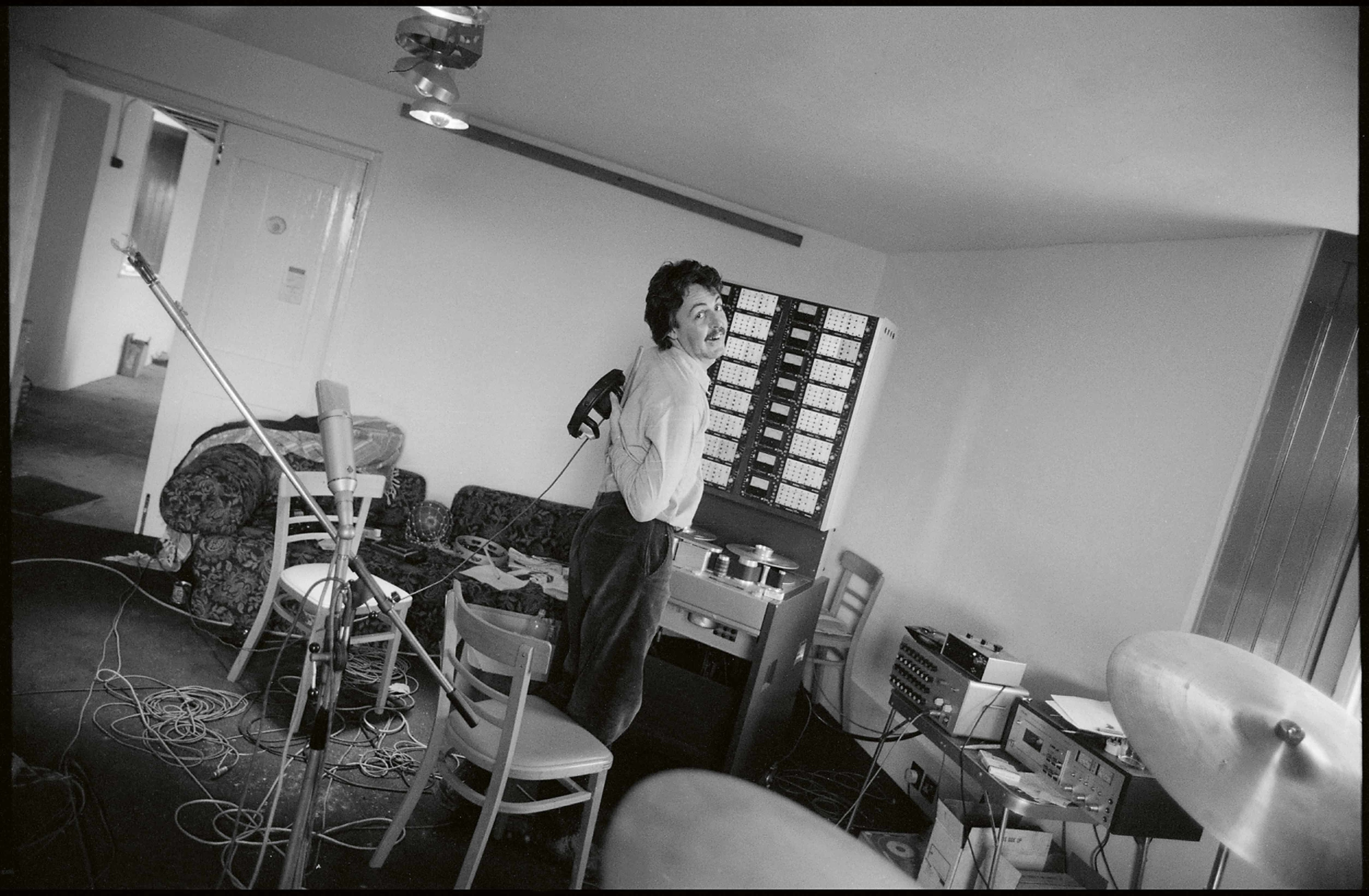 Black and white photo of Paul stood in the centre of his home studio recording 'McCartney II'