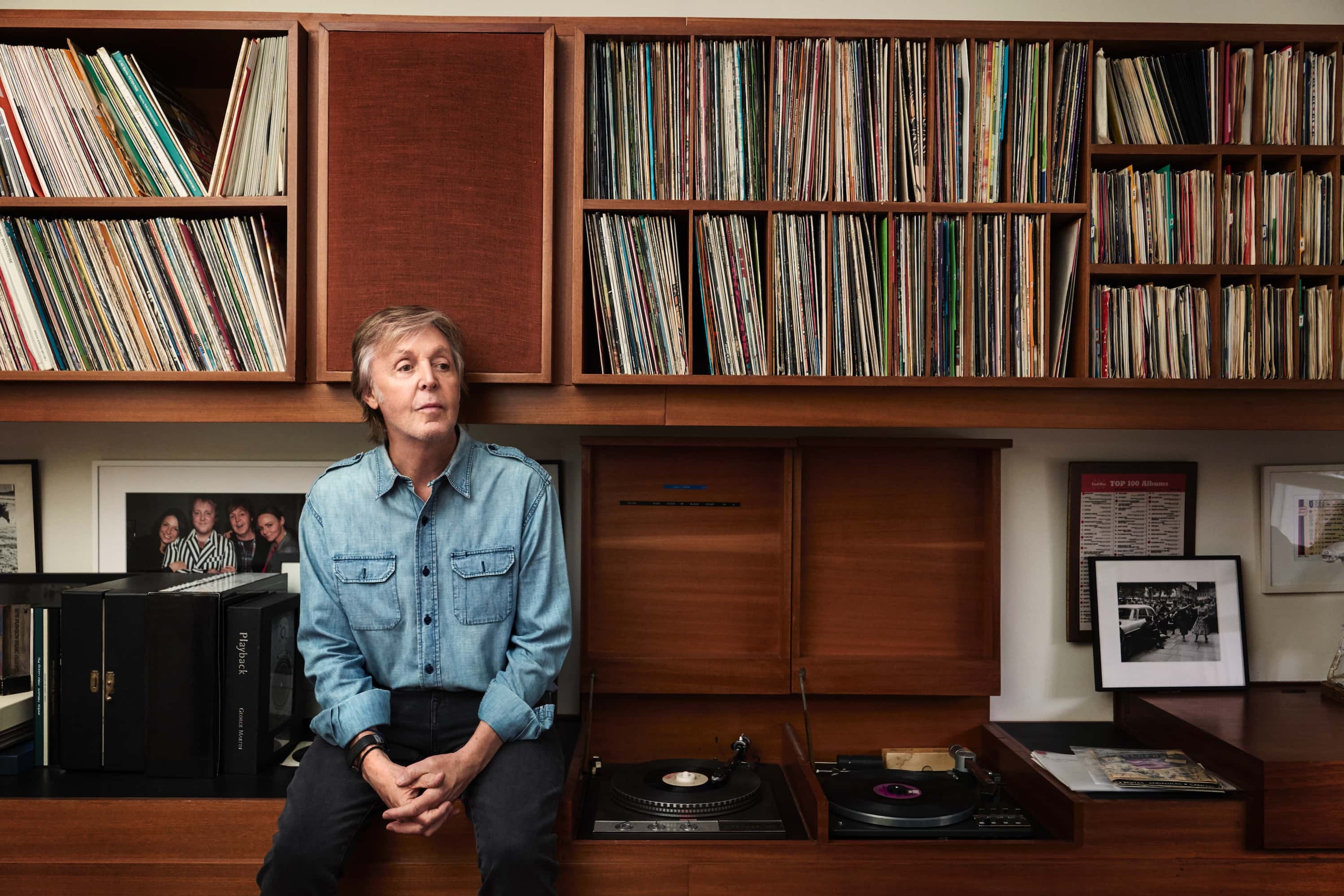 Photo of Paul sat in front of a record collection used to promote The 7” Singles Box release.