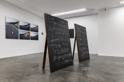 Two chalkboards with mathematical equations
