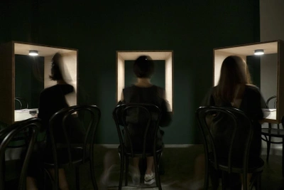 Three women sitting and facing an open box 