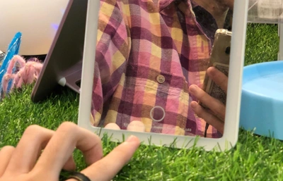 Weixin Chong takes a selfie in a touchscreen mirror.