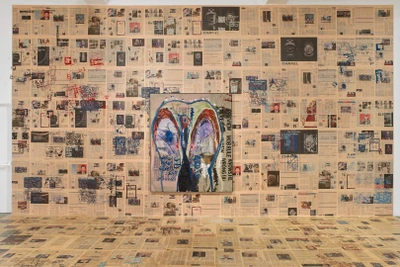 Newspaper cutouts with a painting in the centre