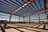 workers talking under a large steel structure. 