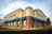 Aspen Dental building corner view. Stone and brick building with blue awnings and the white and blue Aspen Dental logo.