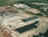 Large manufacturing facility with metal buildings, equipment, and supplies in multiple sections on the property