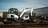 A white Bobcat tractor breaking up asphalt at a job site