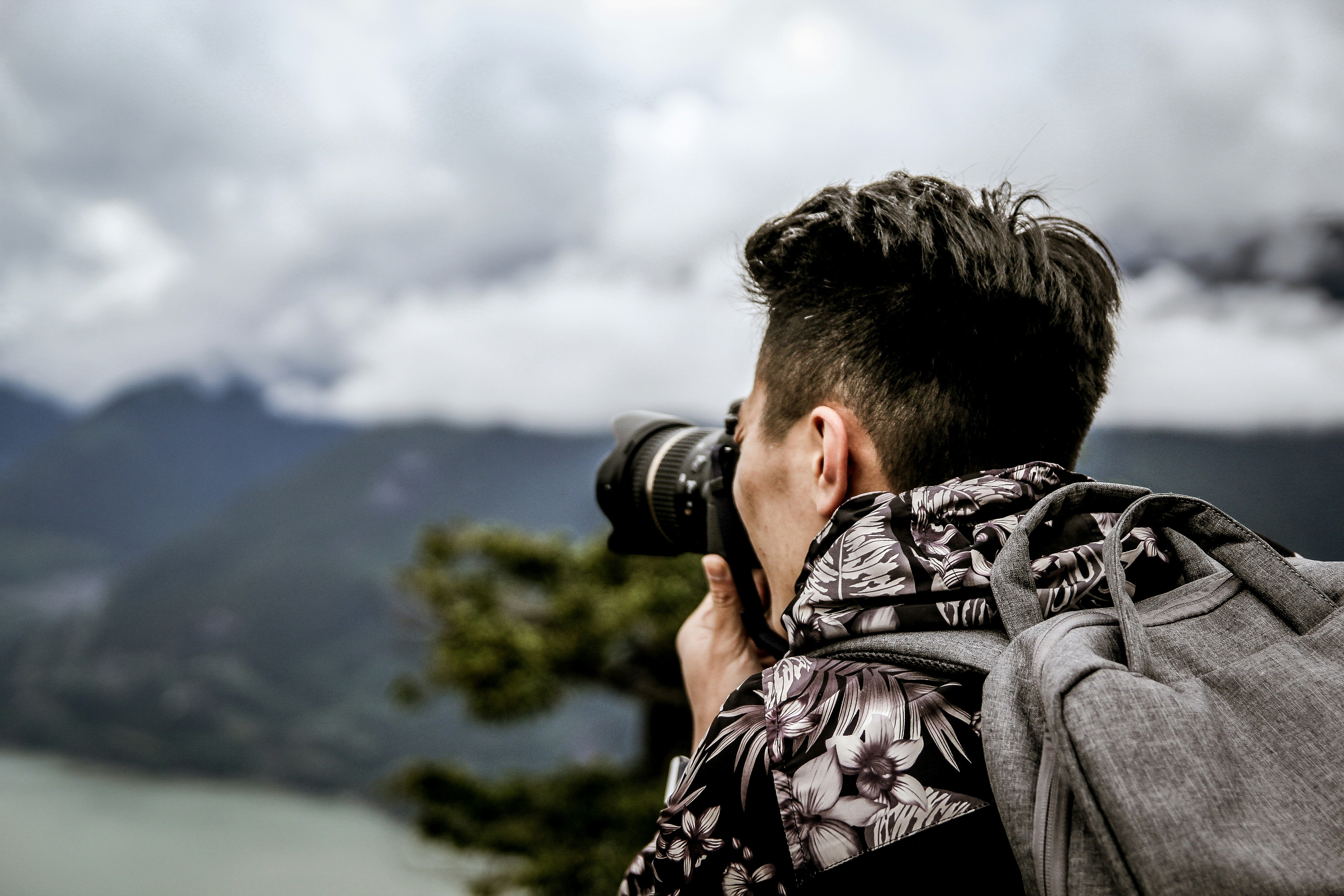 Side hustle seorang lelaki sebagai fotografer yang memotret pemandangan gunung. (Photo by Brendan Church on Unsplash)