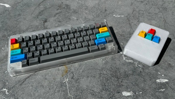 Macropad next to RAMA Kara keyboard on stone surface