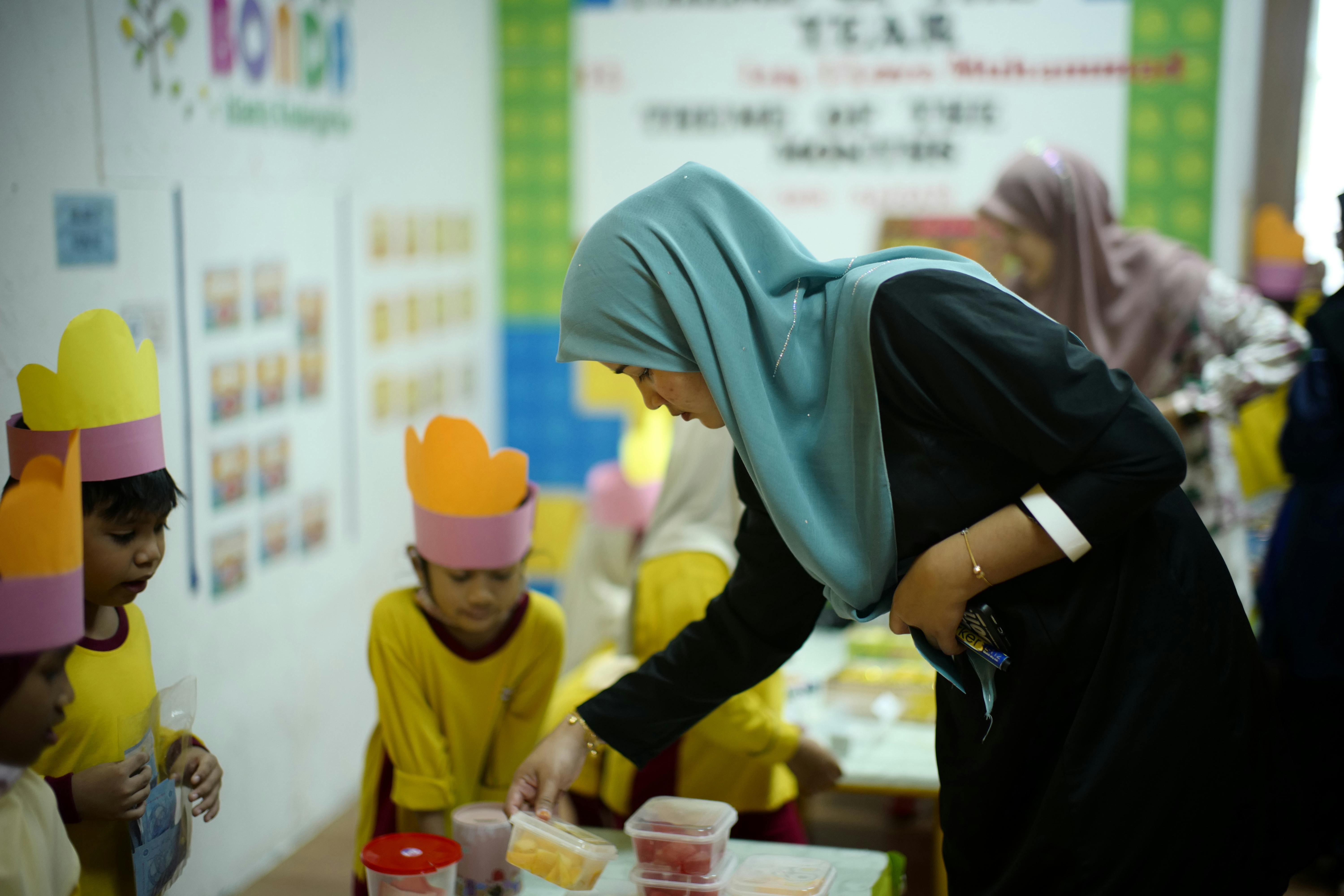 seorang wanita sedang bekerja di Malaysia sebagai guru sekolah