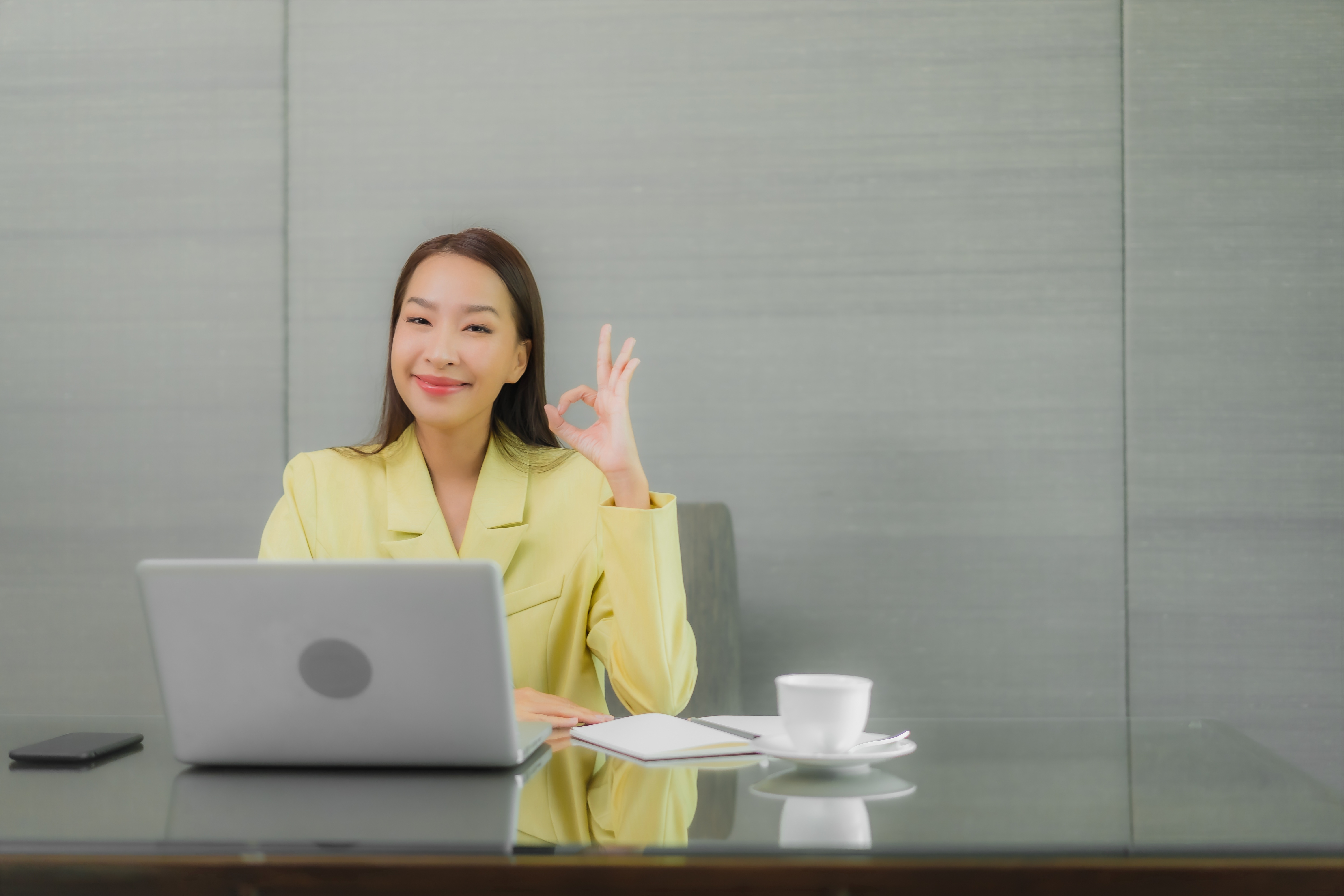 Seorang wanita tampak bahagia setelah mengikuti zoom meeting di kantor. (Image by lifeforstock on Freepik)