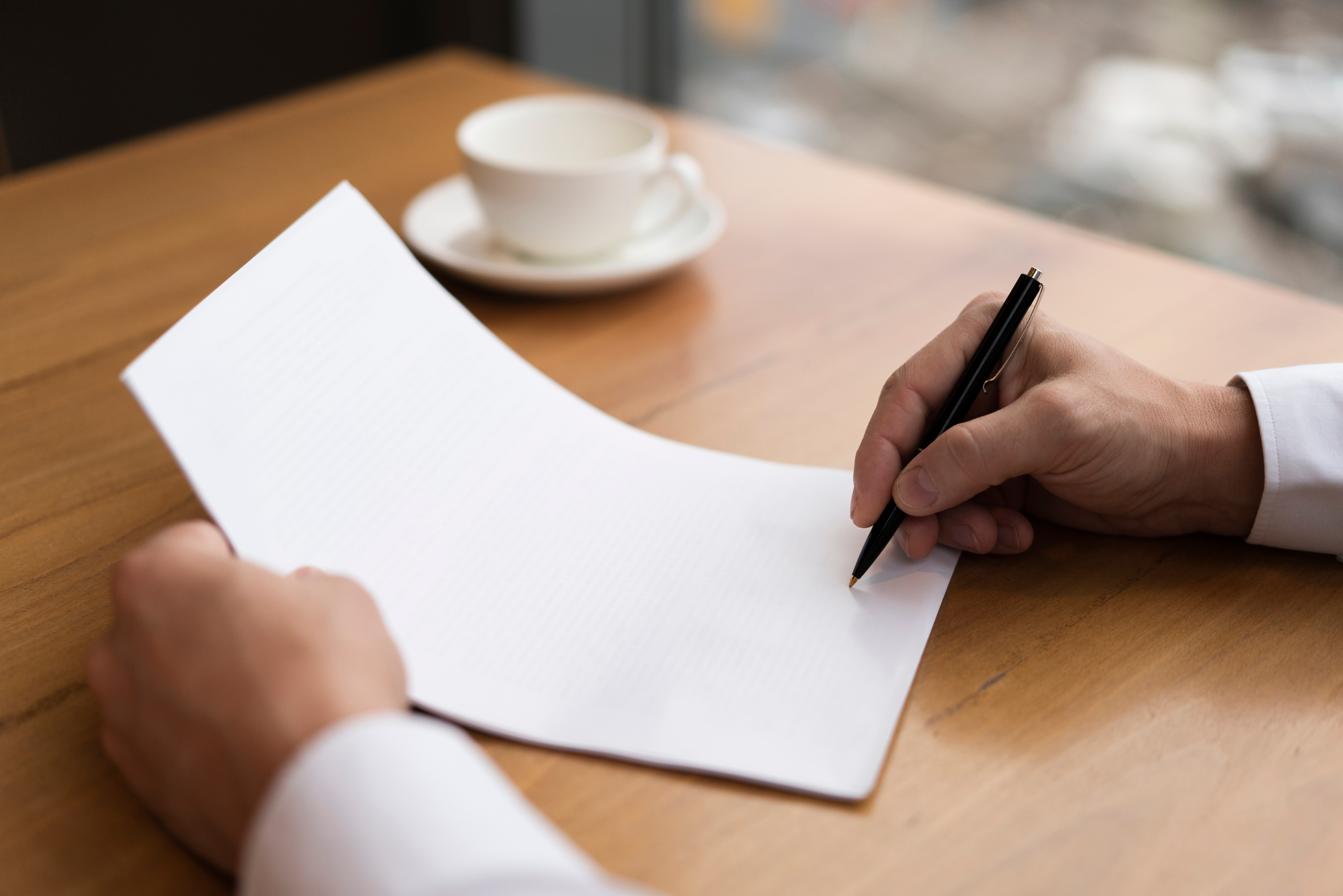 seorang sedang mulai menulis surat tugas resmi di atas kertas putih. (Image by freepik)