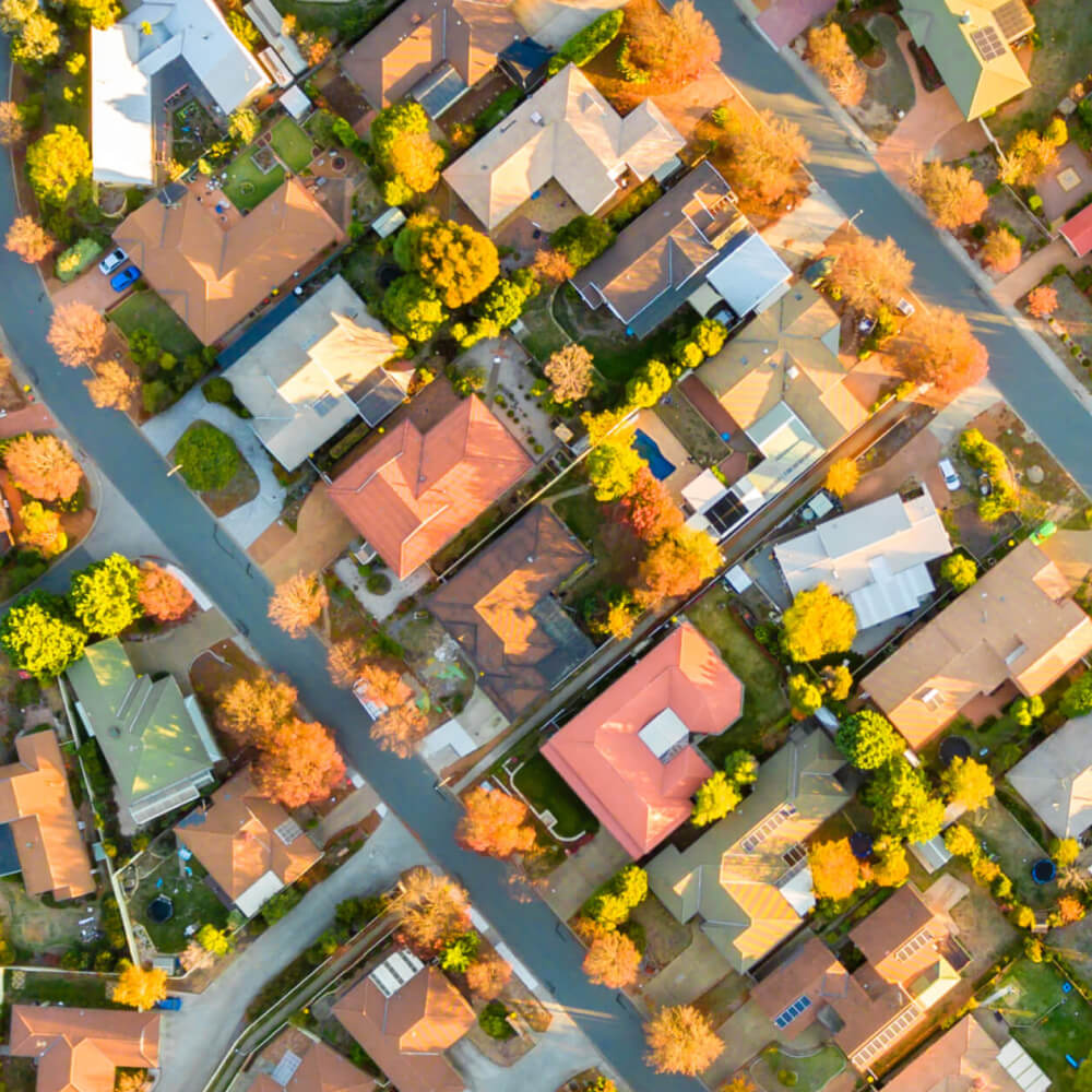 Birds-eye view of rooftops in ACT with solar panels