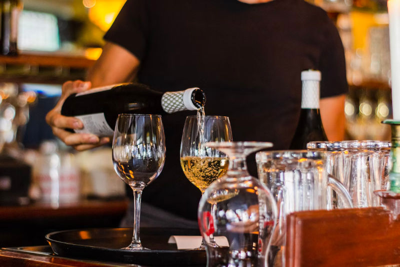 Server pouring wine.