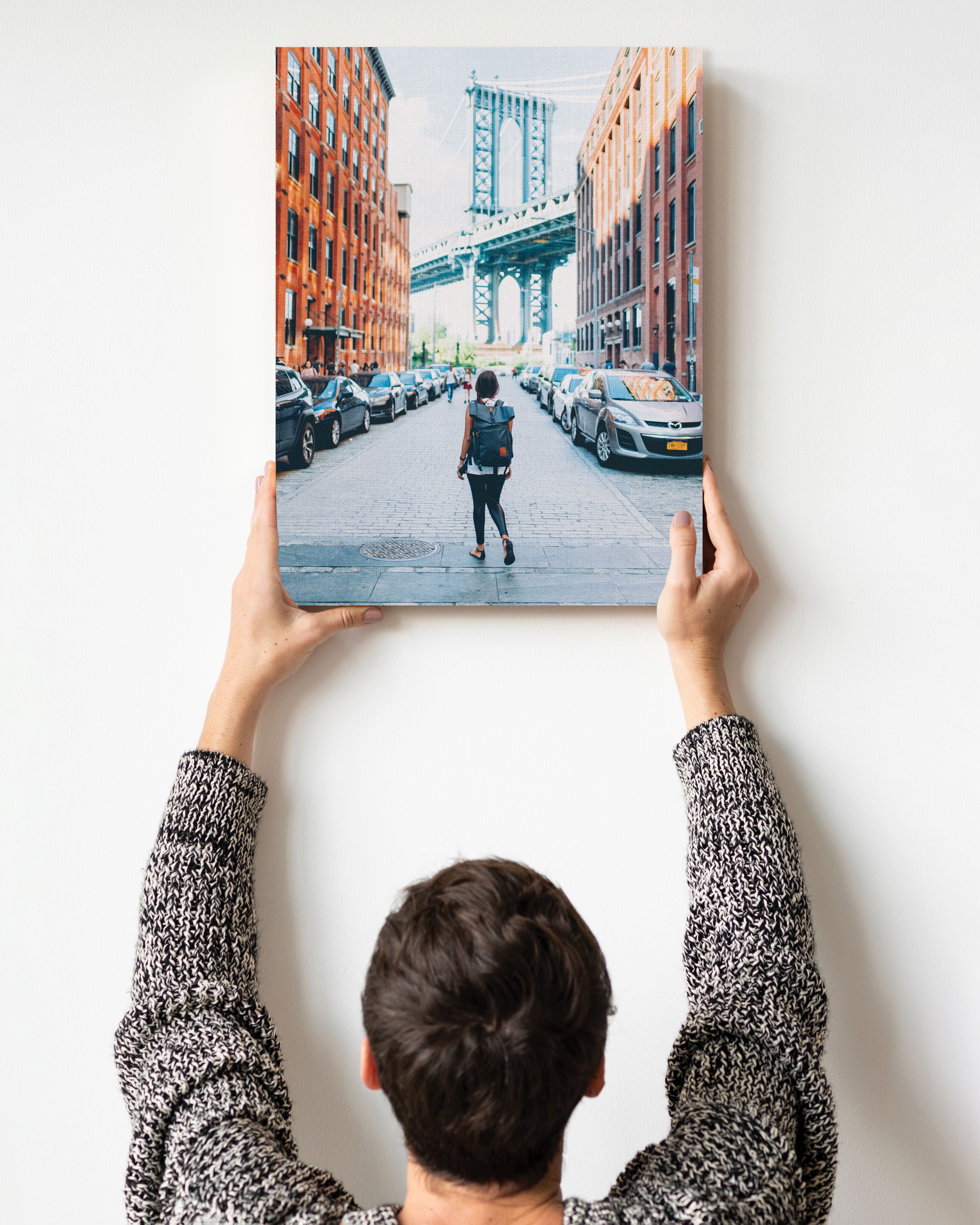 Photo of a person hanging canvas print on wall