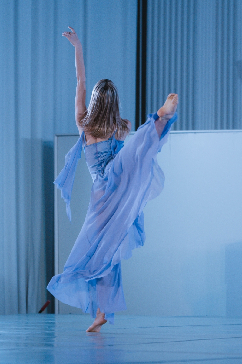 a dancer in a blue dress does a dance move