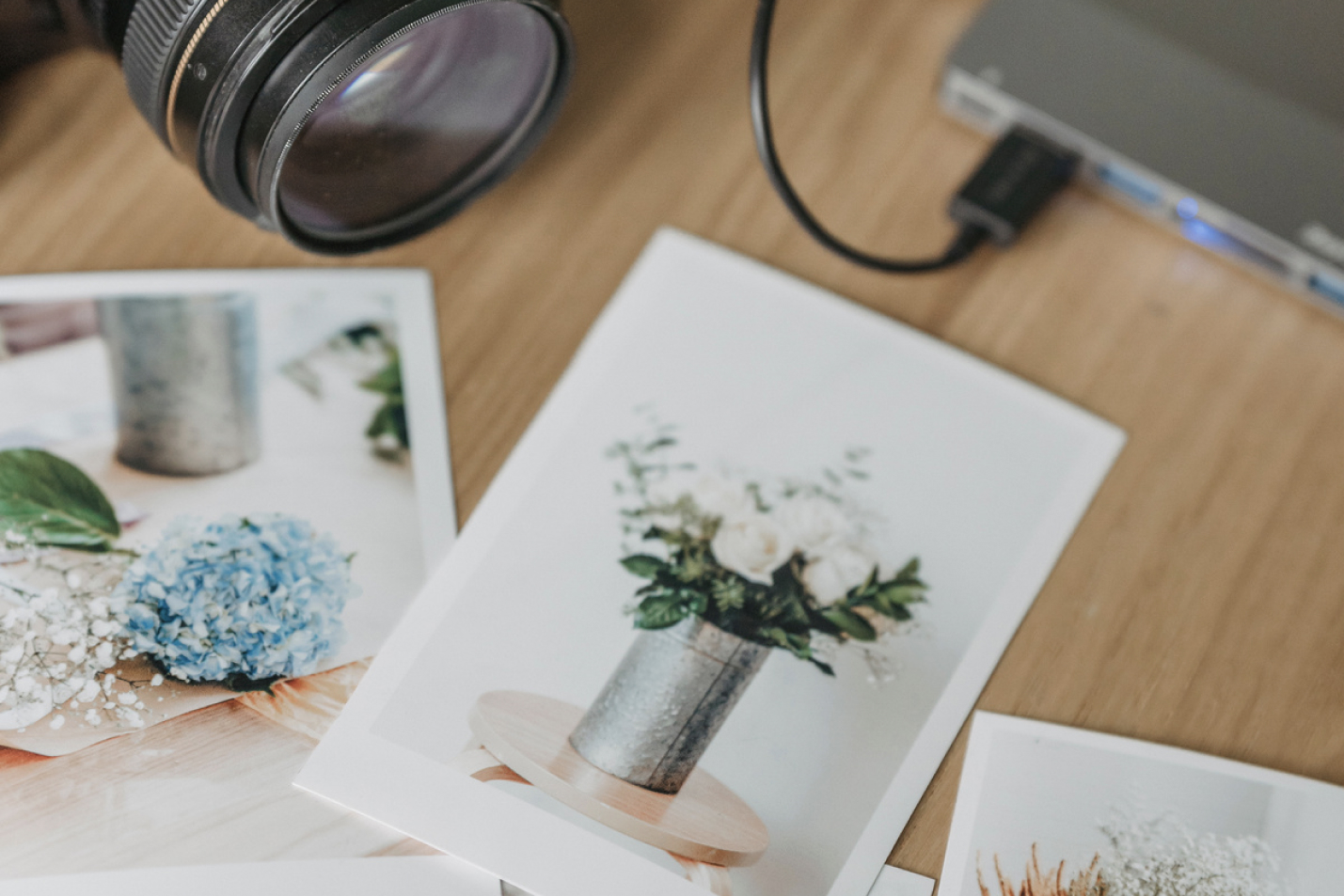 Polaroids and a dlsr camera on a wooden table