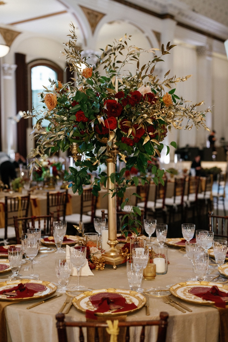 a wedding reception table with rose centerpiece at an indoor DTLA cathedral ballroom wedding reception