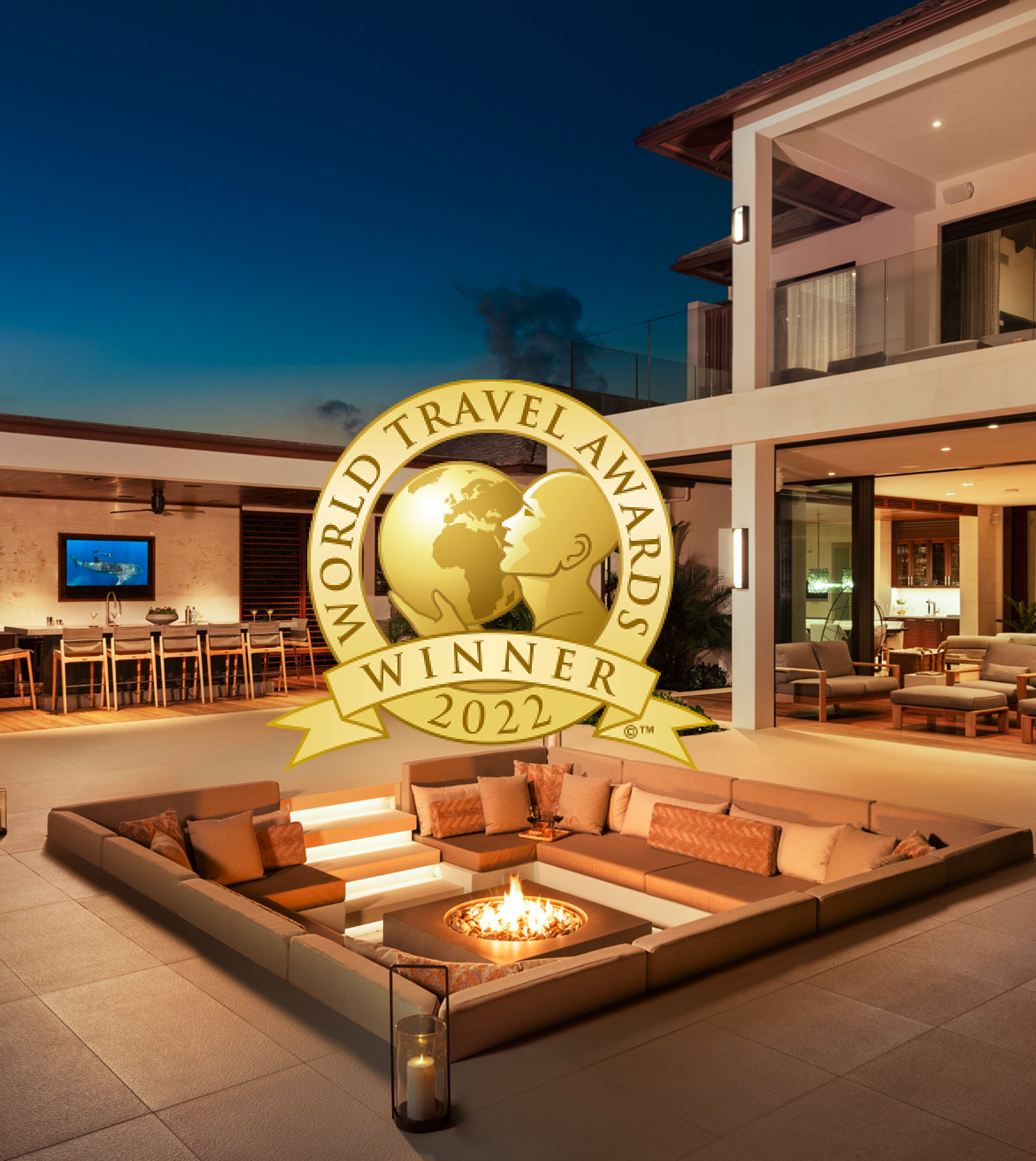 A luxury villa with an outdoor fire pit with the gold Word Travel Awards logo over the top