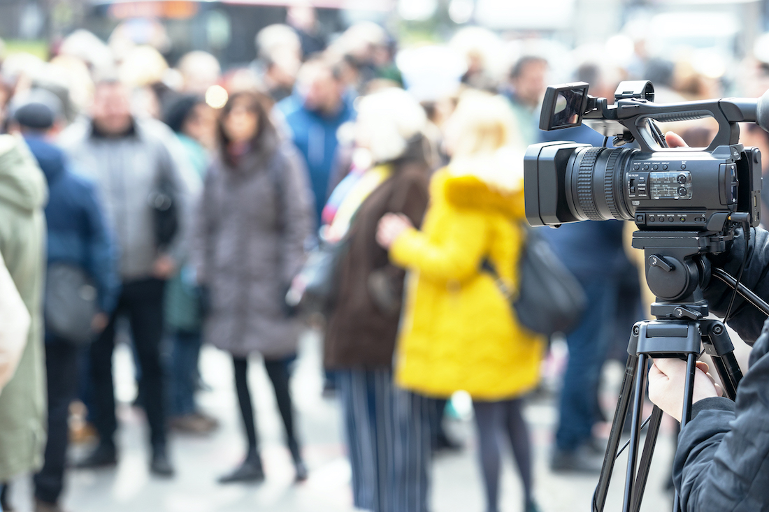 Cameraperson filming a crowd outdoors.jpg