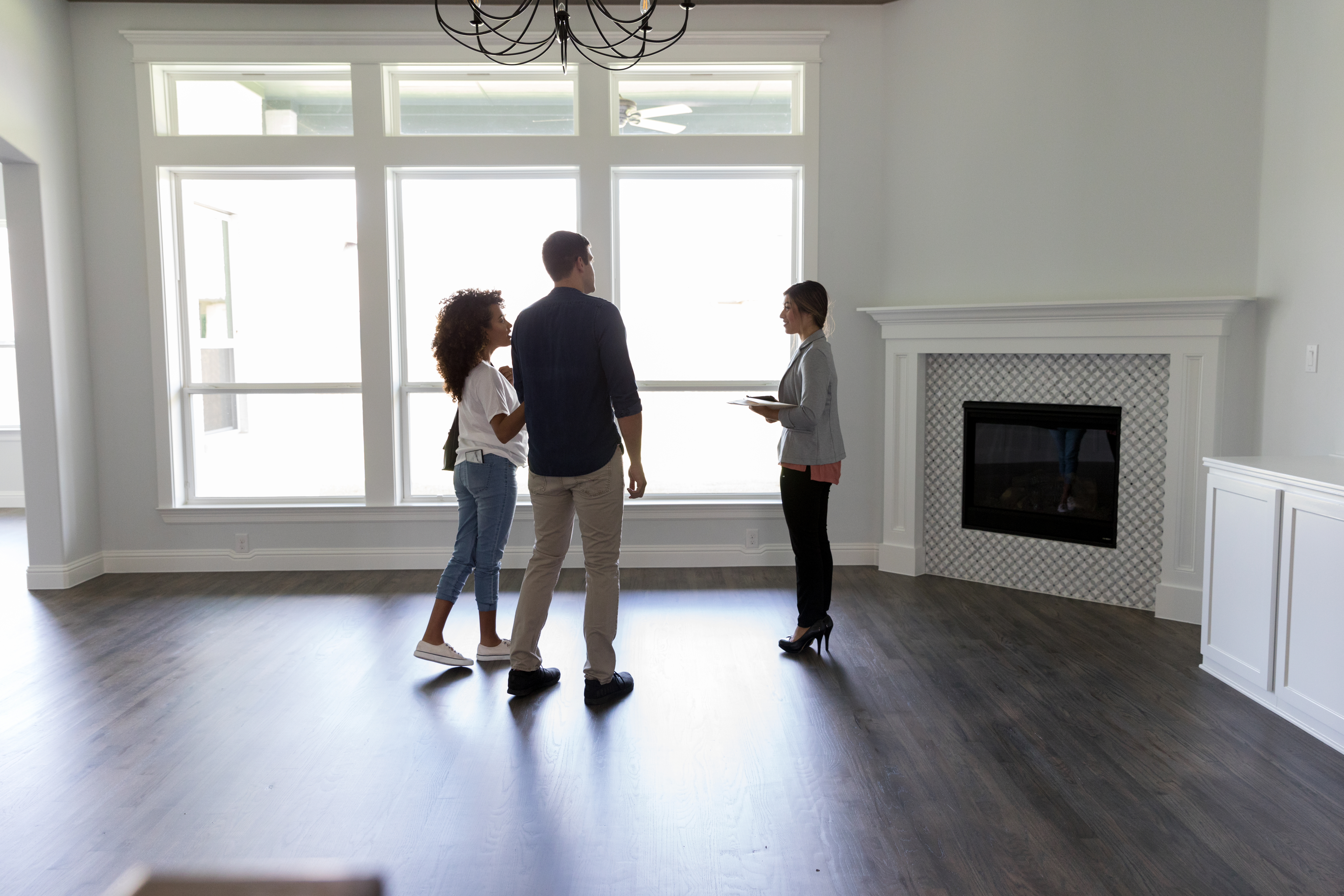 Real Estate Agent showing young couple a new listing