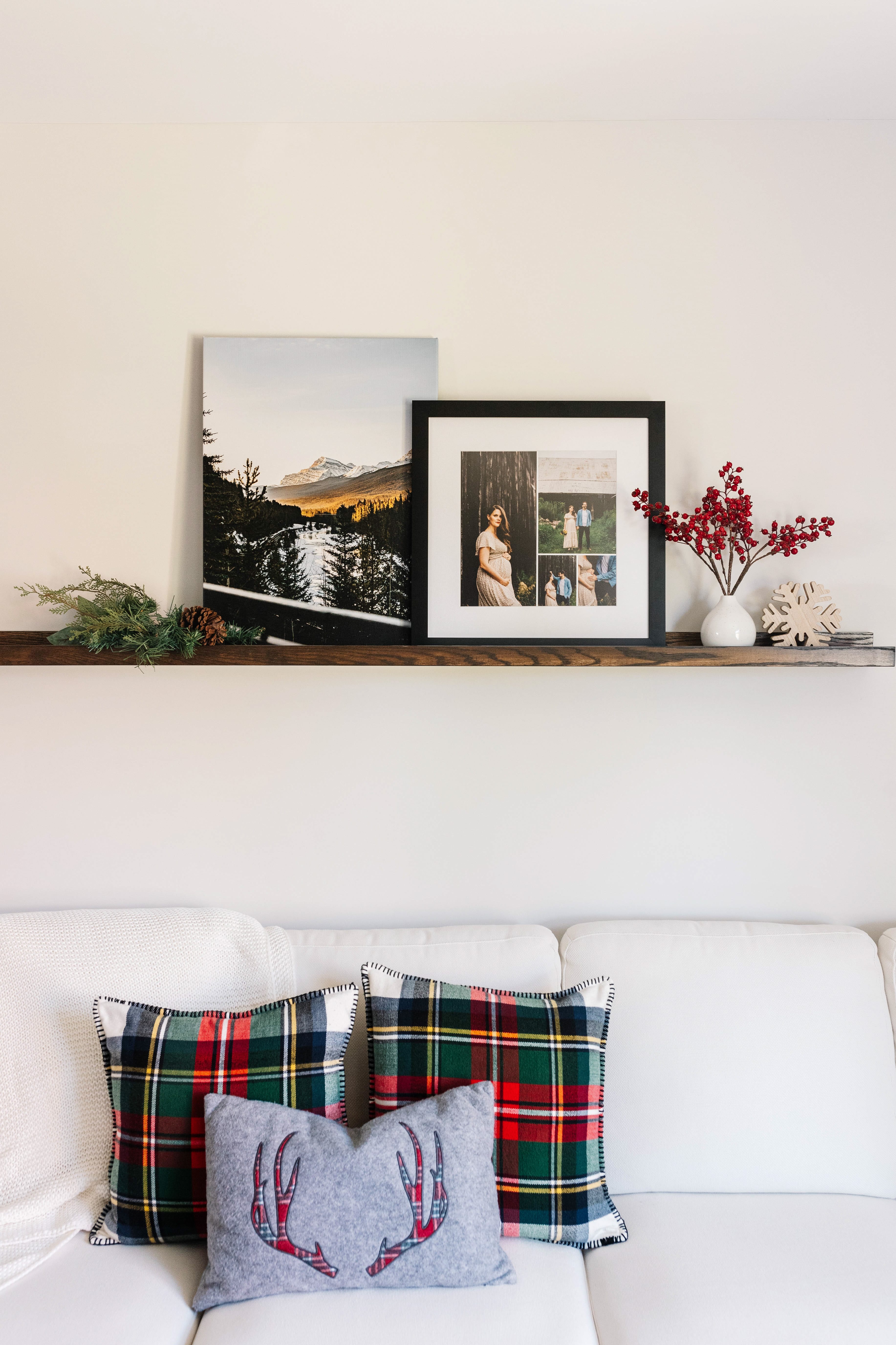 Canvas print of mountain and framed collage of family hung on a shelf